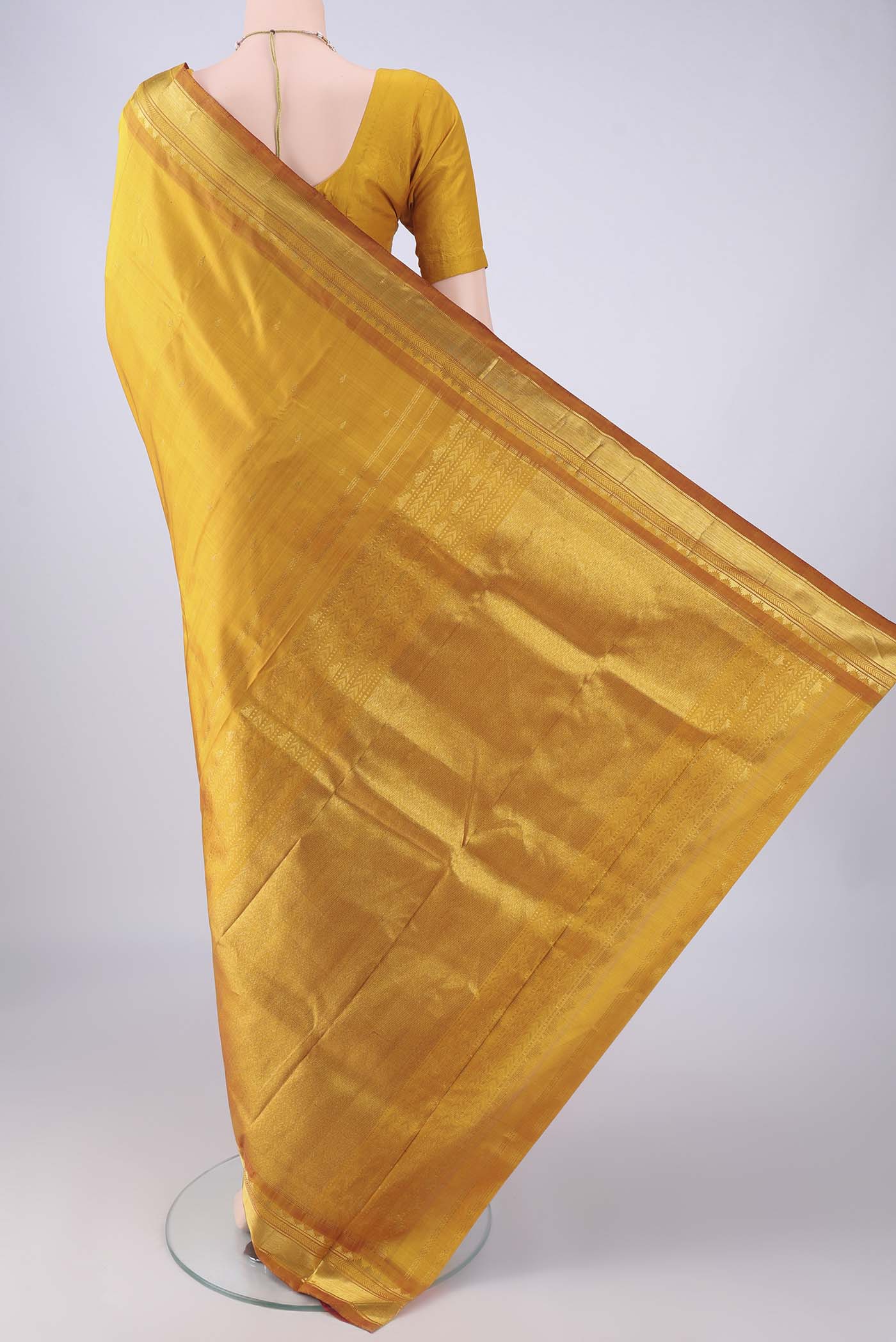 Flat view of Mustard Kanchipuram Silk Saree with Zari Butta on the body and Zari Border. 