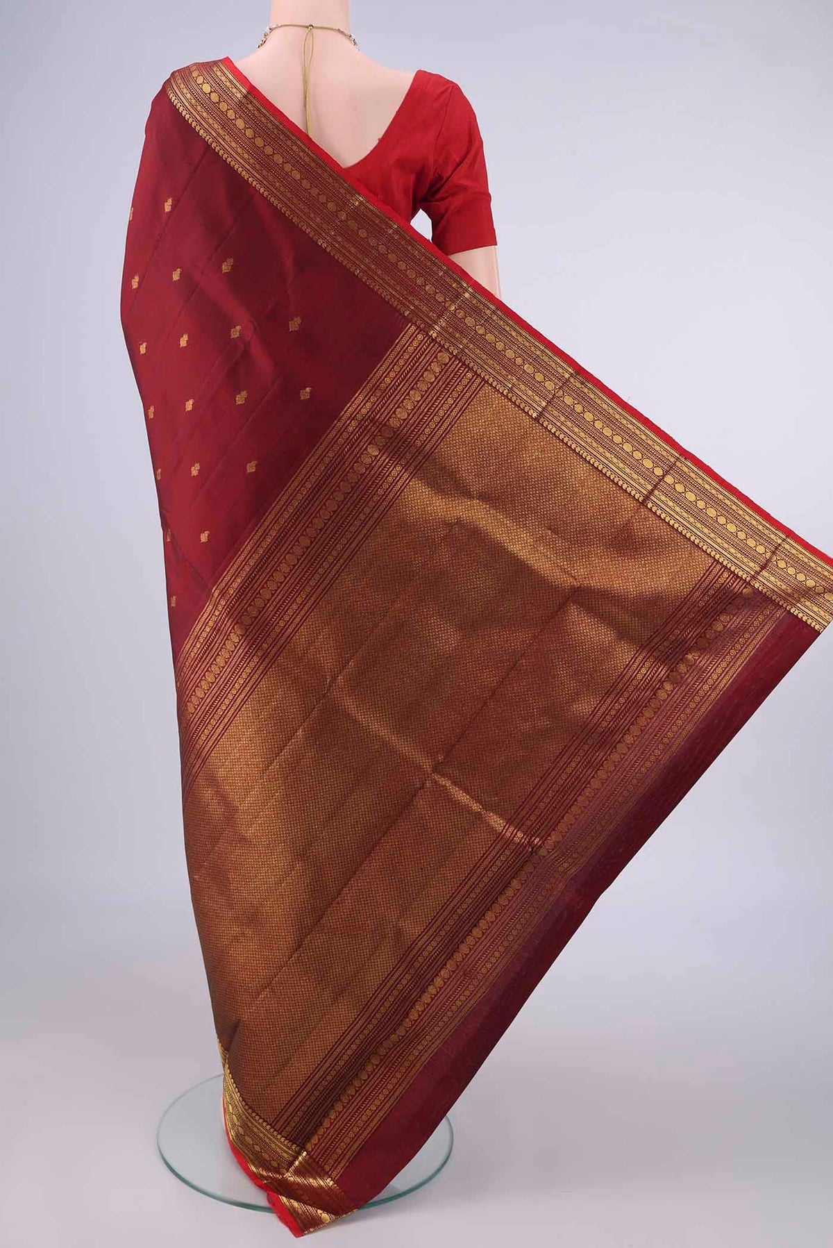 Flat view of Pure Silk Maroon Kanjivaram Saree with Zari Butta on the body and Zari Border. 