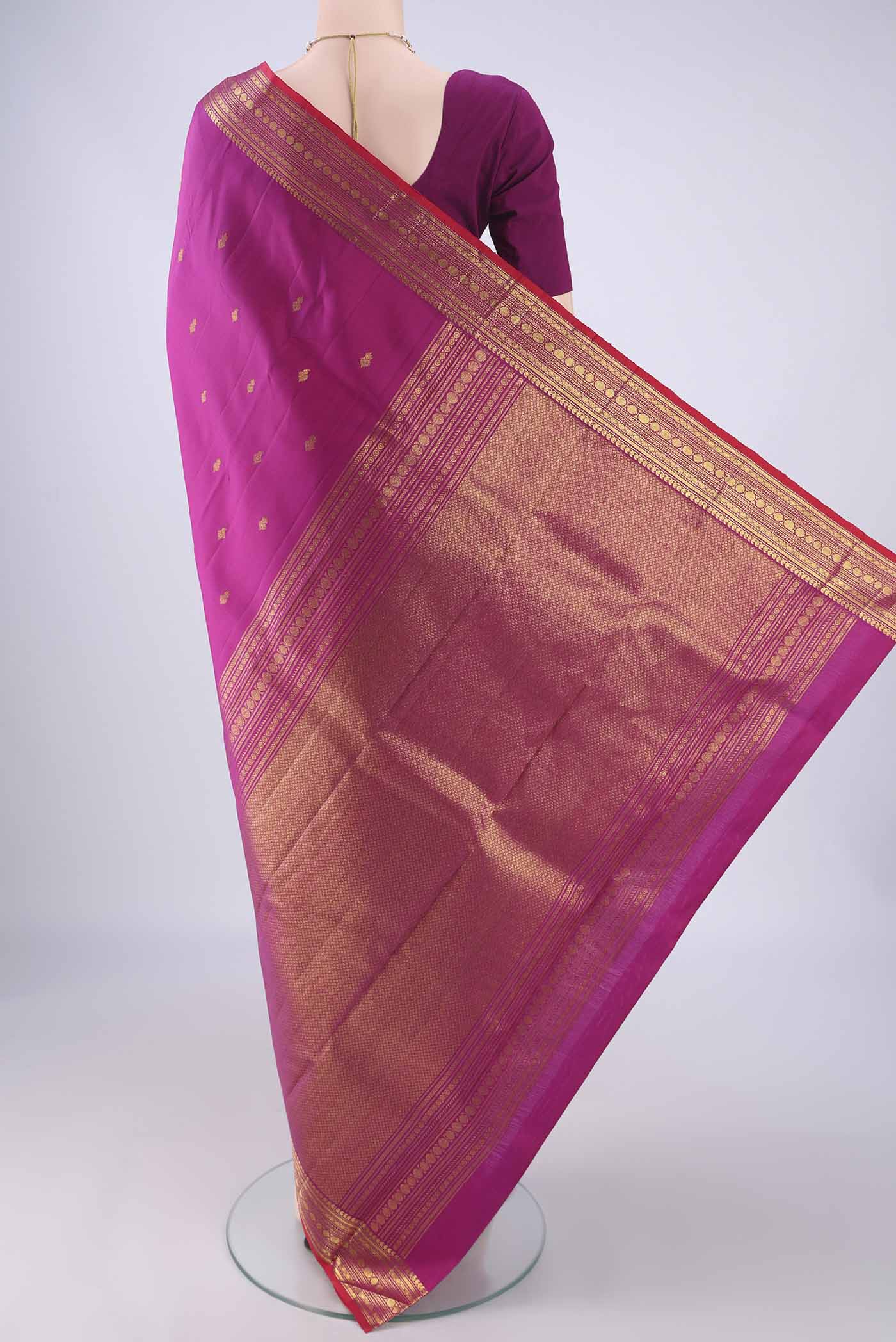 Flat view of Pure Silk Magenta Kanjivaram Silk Saree with Zari Butta on the body and Zari Border. 