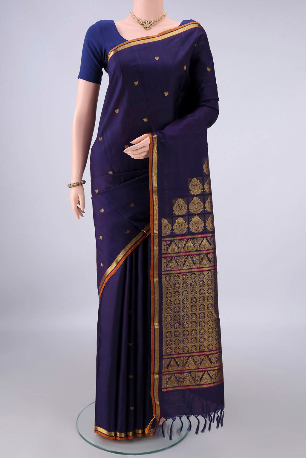 Pure Silk Navy Blue Kanjivaram Saree with Zari Butta on the body and Zari Border.  displayed on a mannequin