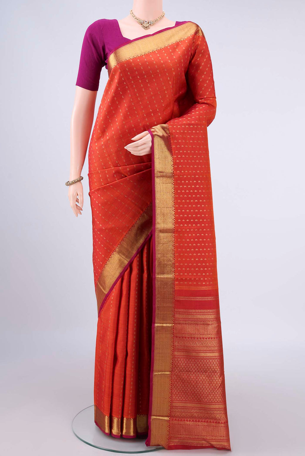 Pure Silk Pure Zari Orange Kanjivaram Saree with Zari Butta on the body and Zari Border.  displayed on a mannequin