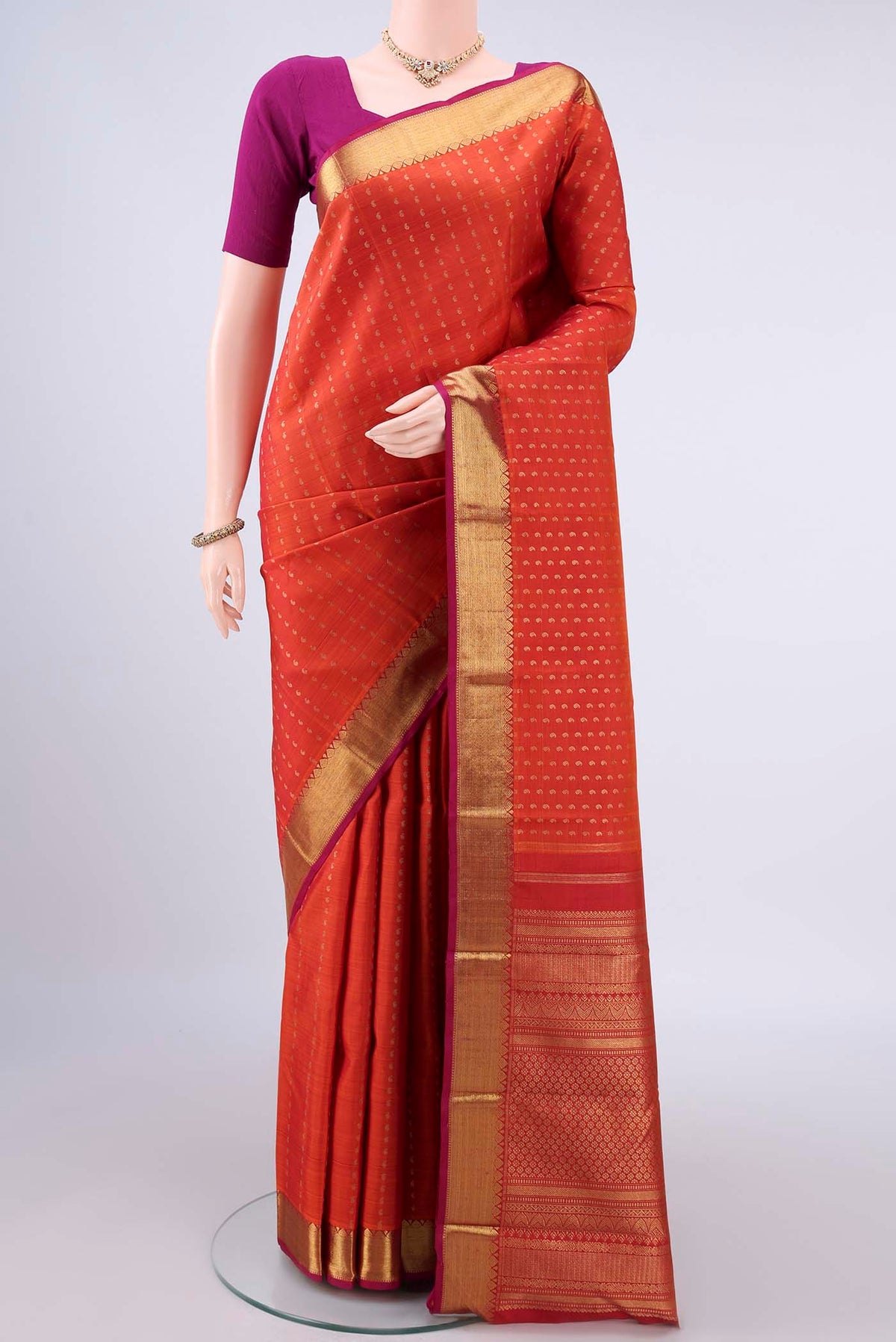 Pure Silk Pure Zari Orange Kanjivaram Saree with Zari Butta on the body and Zari Border.  displayed on a mannequin