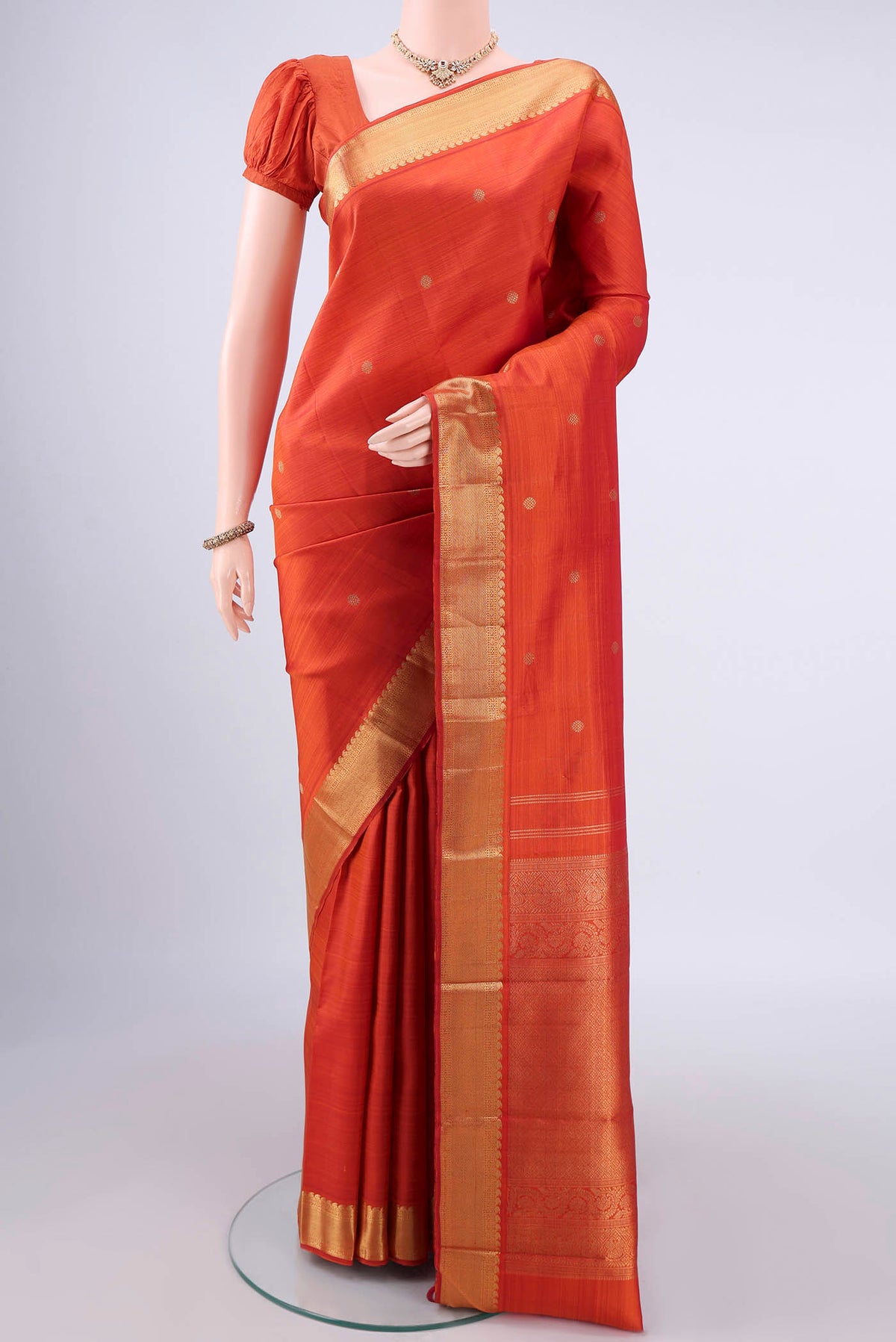 Pure Silk Pure Zari Brick Orange Kanjivaram Saree with Zari Butta on the body and Zari Border.  displayed on a mannequin