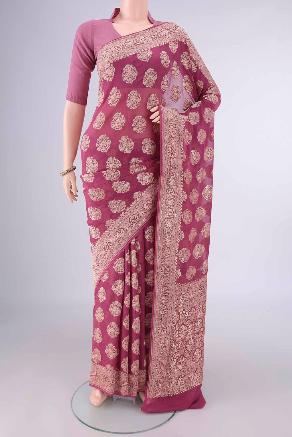 Mauve Banarasi Georgette Saree with Zari Butta on the body and Zari Border.  displayed on a mannequin