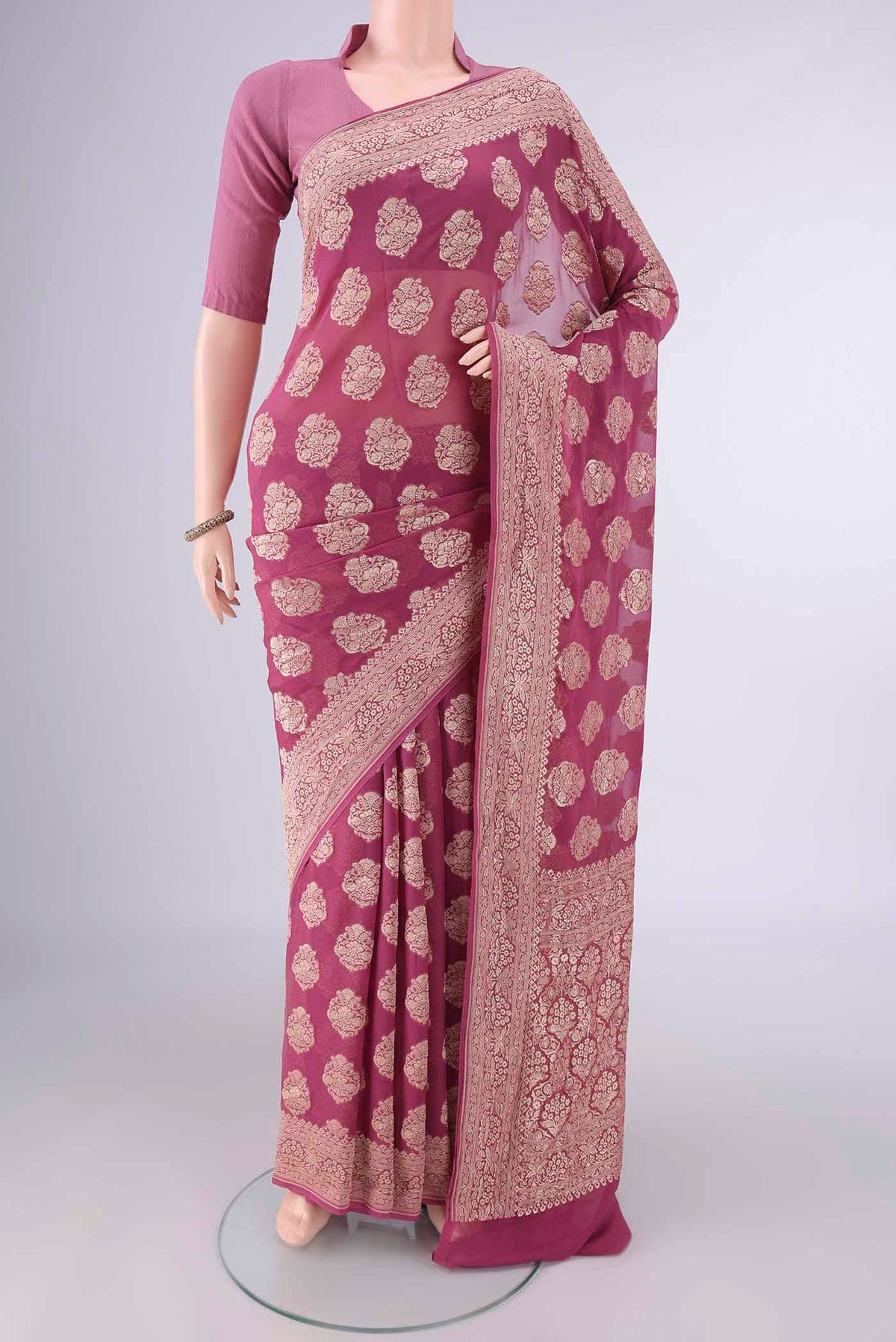 Mauve Banarasi Georgette Saree with Zari Butta on the body and Zari Border.  displayed on a mannequin