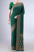 Bottle Green Banarasi Georgette Saree with Zari Butta on the body and Zari Border.  displayed on a mannequin