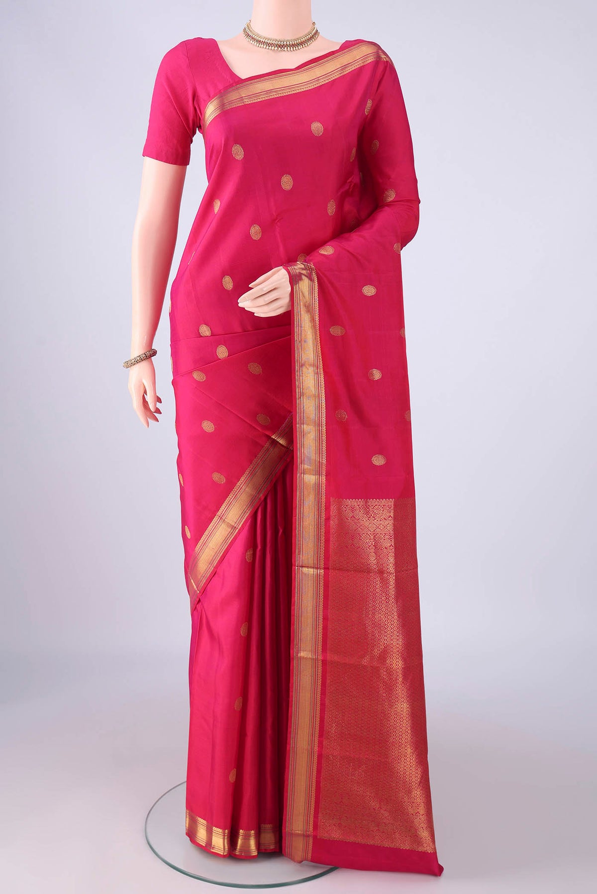Rani Pink Kanjivaram Silk Saree with Zari Butta on the body and Zari Border.  displayed on a mannequin