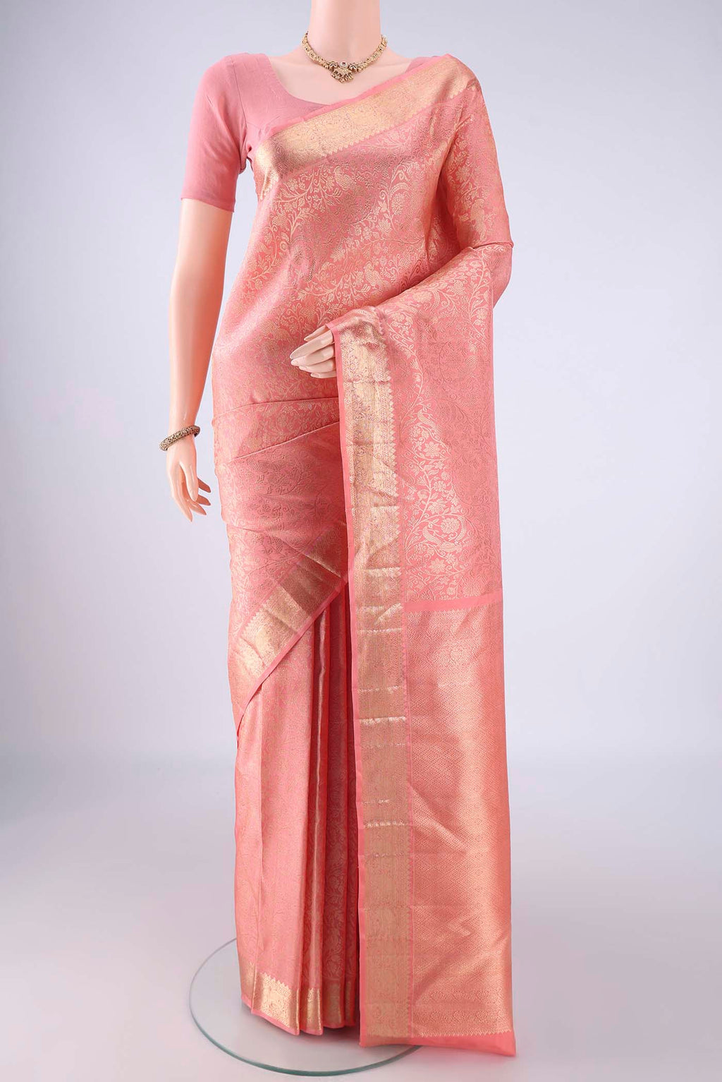 Peach Kanchipuram Silk Saree with Zari Brocade on the body and Zari Border.  displayed on a mannequin