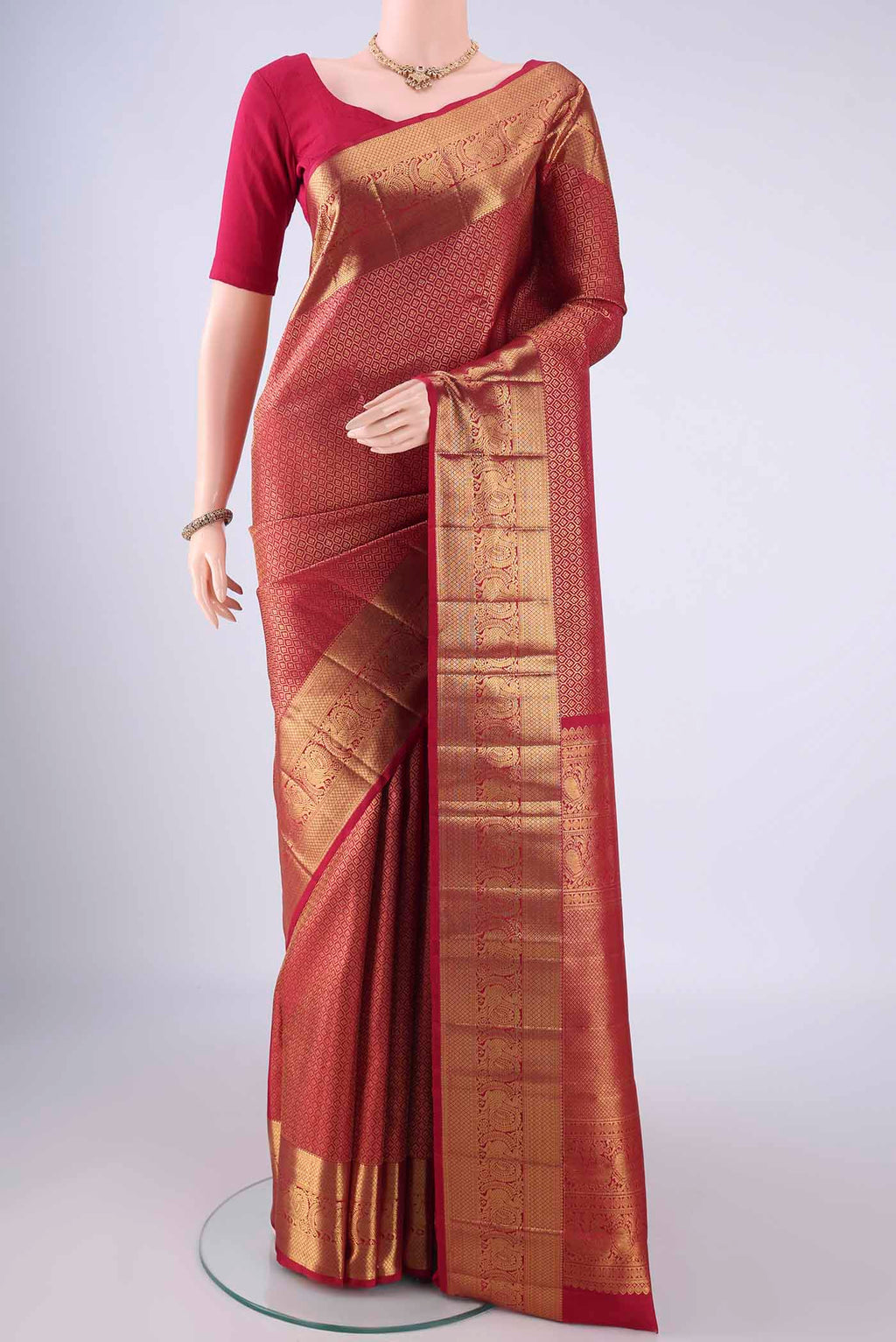Maroon Kanchipuram Silk Saree with Zari Brocade on the body and Zari Border.  displayed on a mannequin