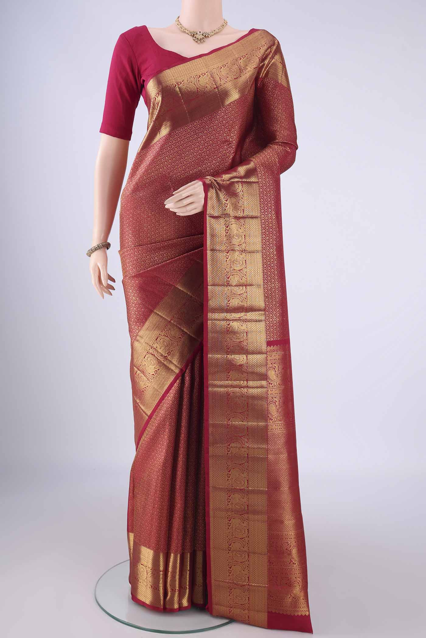 Maroon Kanchipuram Silk Saree with Zari Brocade on the body and Zari Border.  displayed on a mannequin