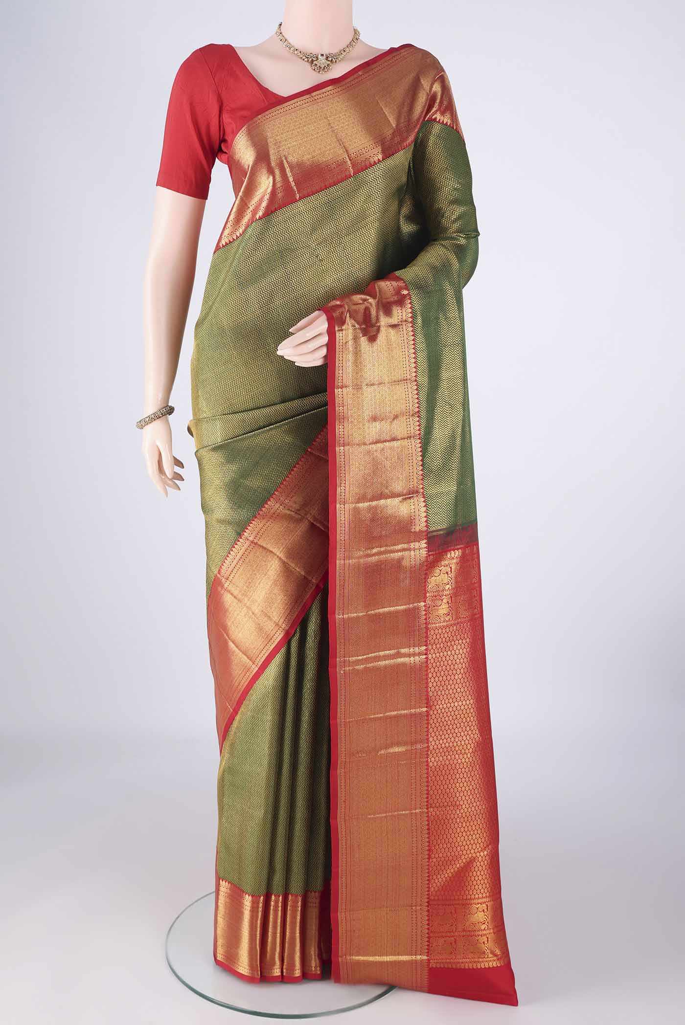Bottle Green Kanchipuram Silk Saree with Zari Brocade on the body and Zari Border.  displayed on a mannequin