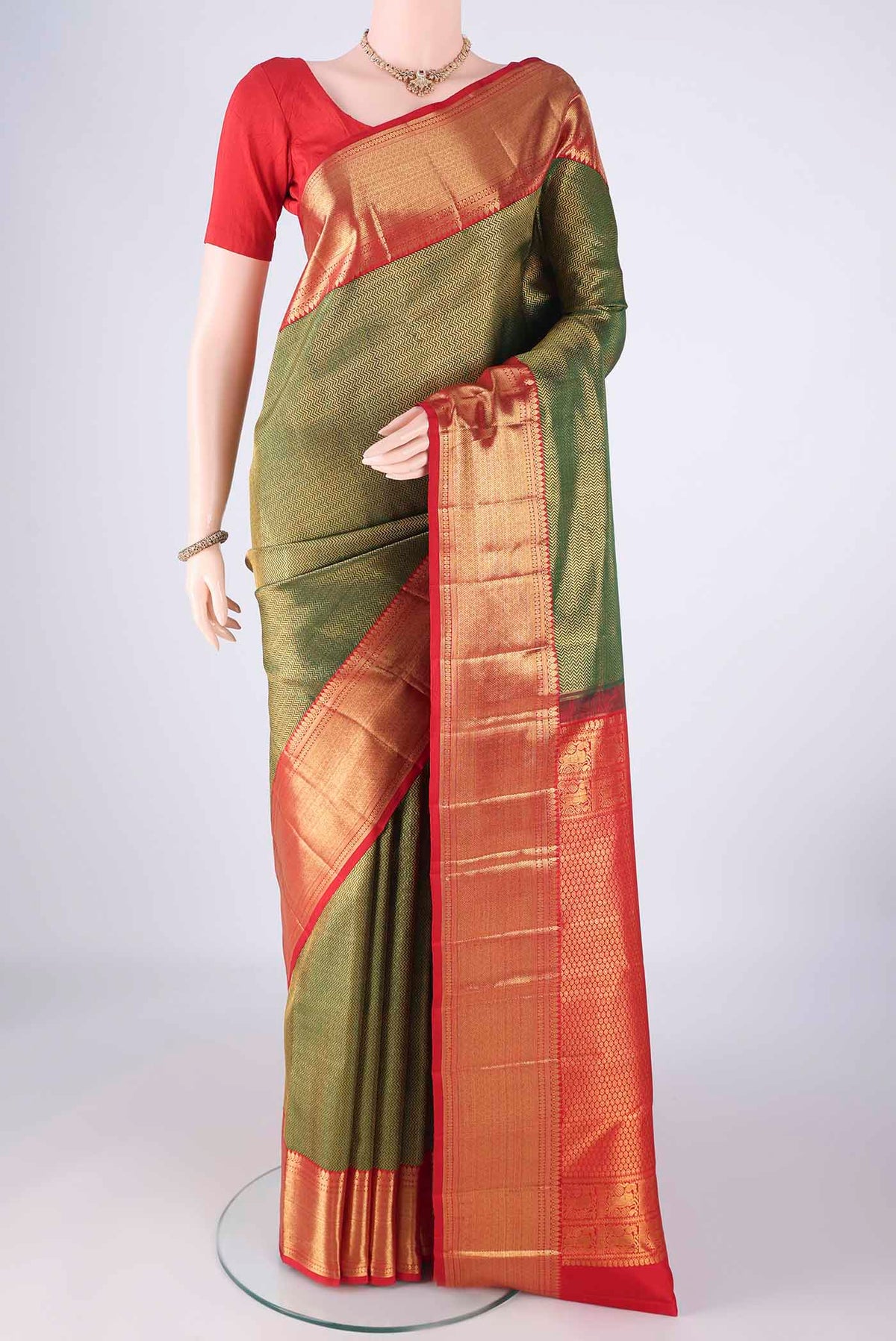 Bottle Green Kanchipuram Silk Saree with Zari Brocade on the body and Zari Border.  displayed on a mannequin