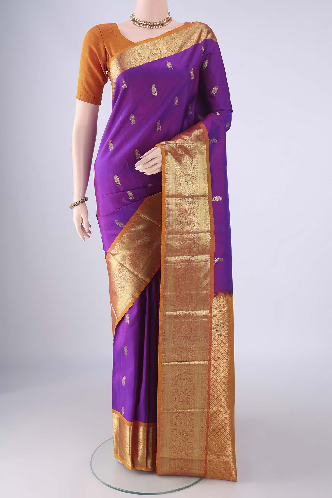 Purple Kanchipuram Silk Saree with Zari Butta on the body and Zari Border.  displayed on a mannequin