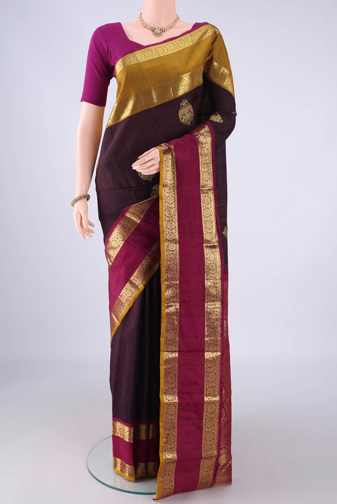 Burgundy Kanchipuram Silk Saree with Zari Butta on the body and Ganga Jamuna Border.  displayed on a mannequin