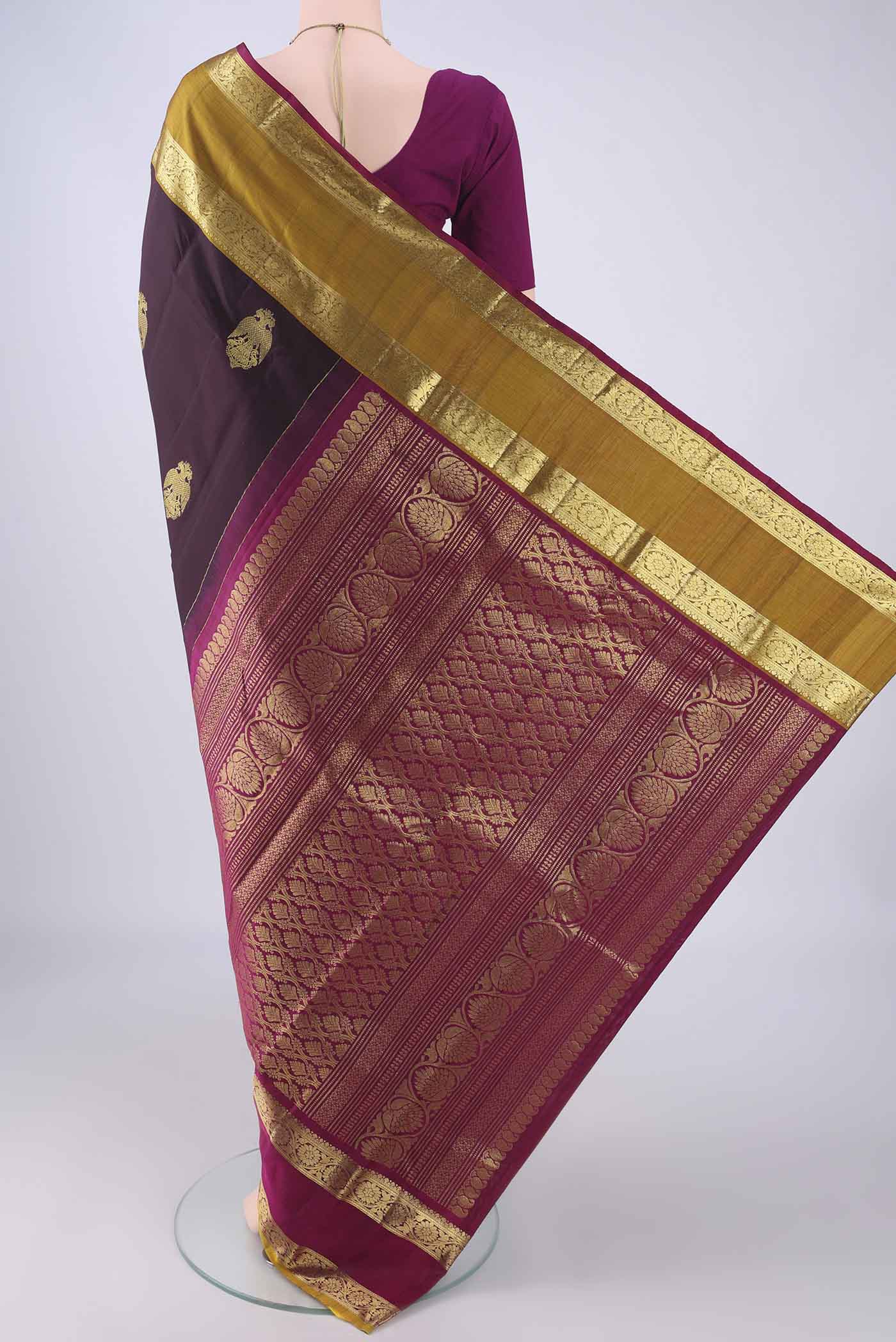 Flat view of Burgundy Kanchipuram Silk Saree with Zari Butta on the body and Ganga Jamuna Border. 