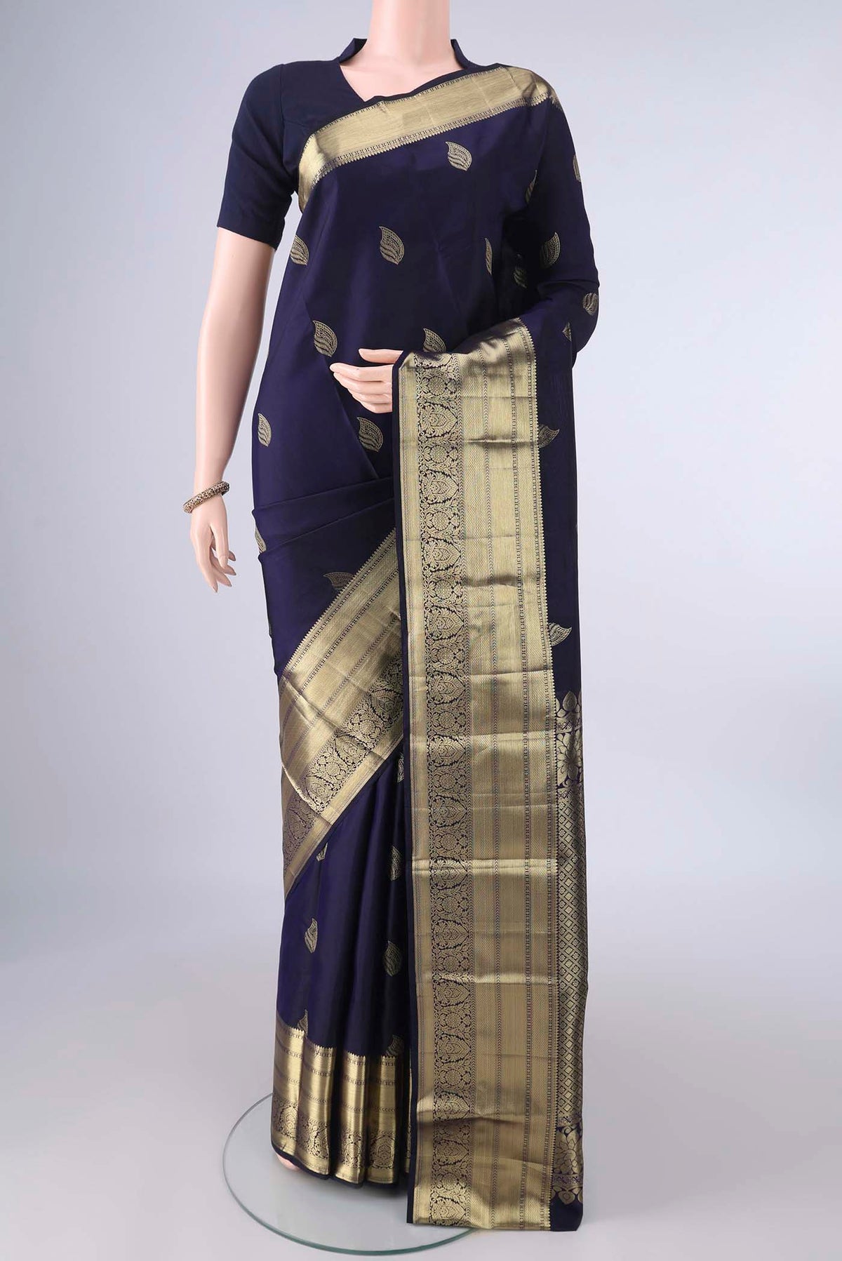 Pure Silk Navy Blue Kanjivaram Saree with Zari Butta on the body and Zari Border.  displayed on a mannequin