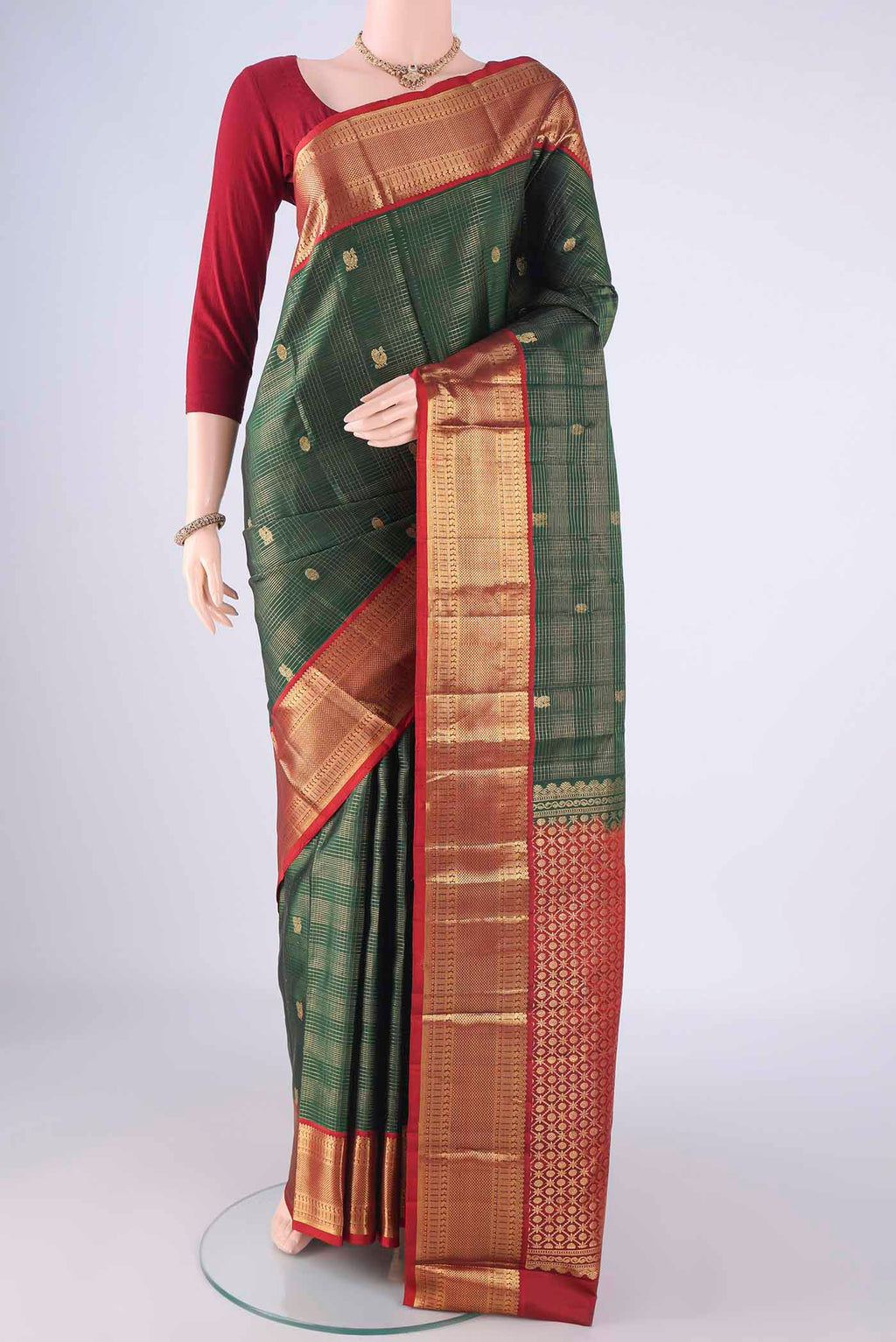 Bottle Green Kanchipuram Silk Saree with Checked design on the body and Zari Border.  displayed on a mannequin