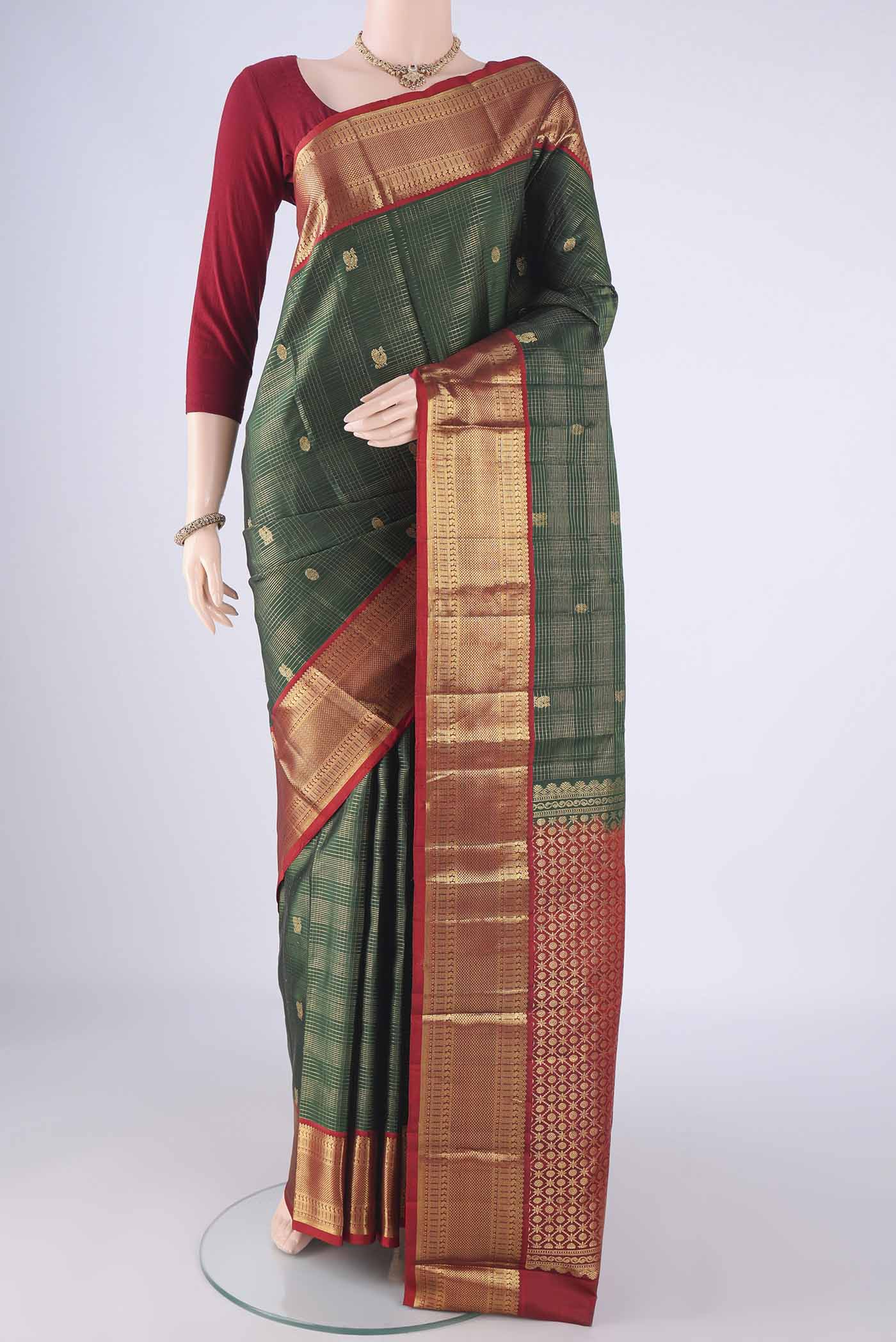 Bottle Green Kanchipuram Silk Saree with Checked design on the body and Zari Border.  displayed on a mannequin