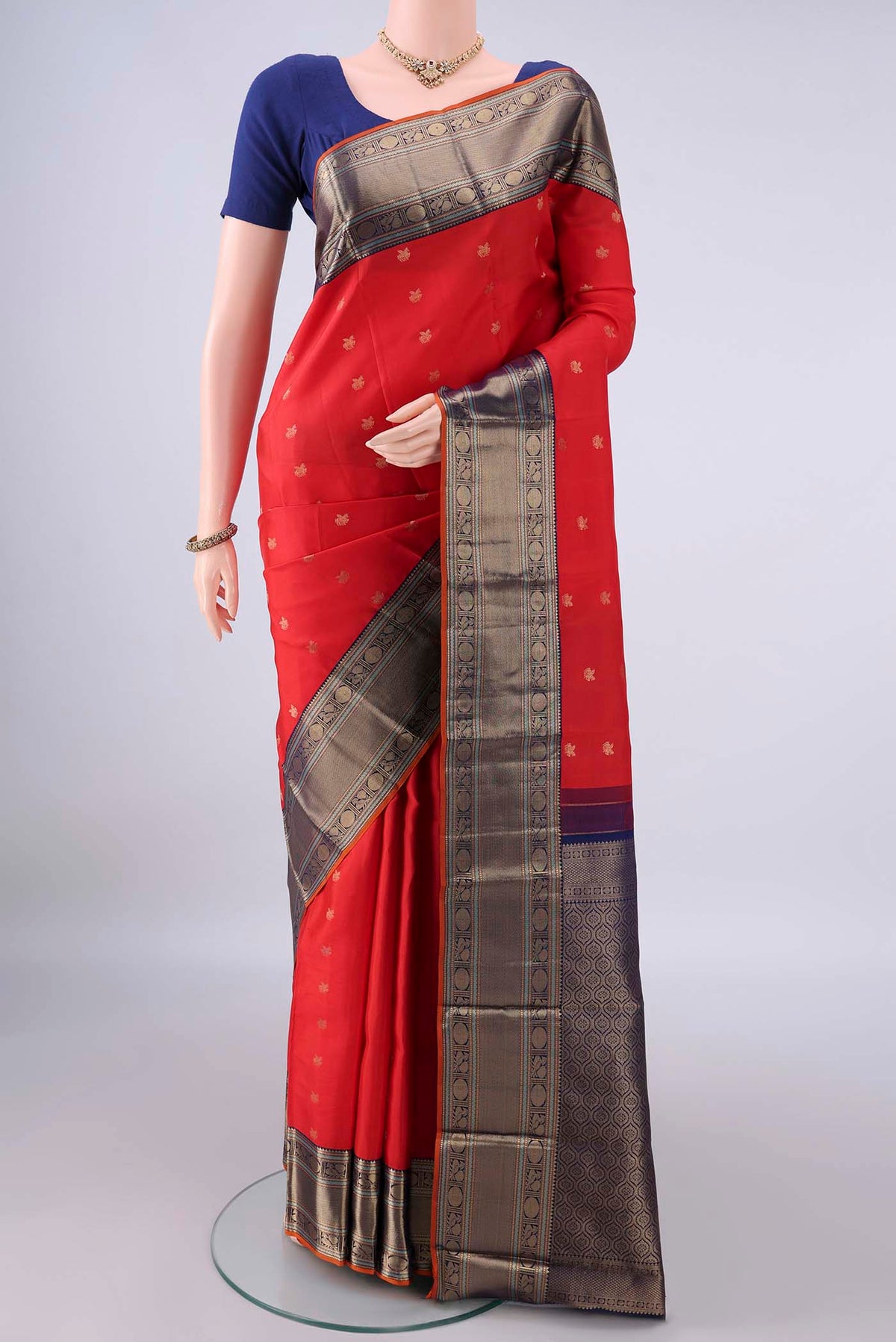 Pure Silk Red Kanchipuram Saree with Zari Butta on the body and Zari Border.  displayed on a mannequin