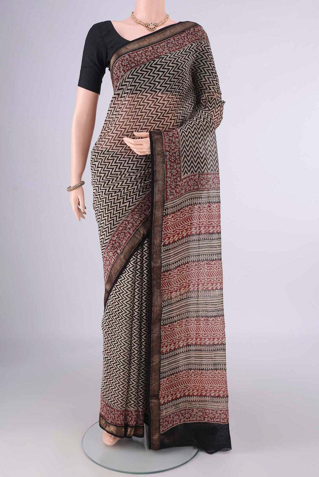 Beige Maheshwari Cotton Saree with Printed design on the body and Zari Border.  displayed on a mannequin