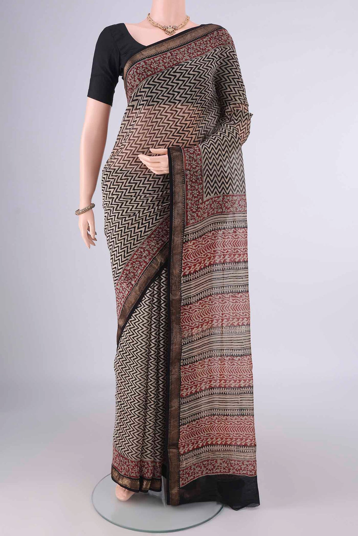 Beige Maheshwari Cotton Saree with Printed design on the body and Zari Border.  displayed on a mannequin
