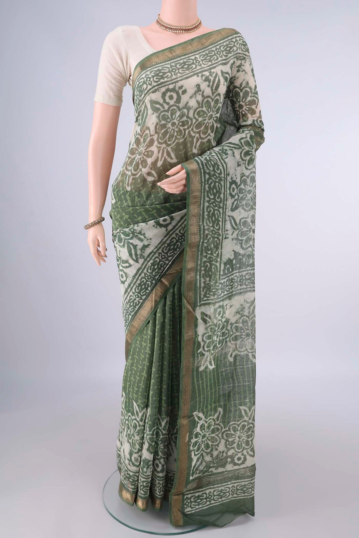 Light Green Maheshwari Cotton Saree with Batik Print on the body and Zari Border.  displayed on a mannequin