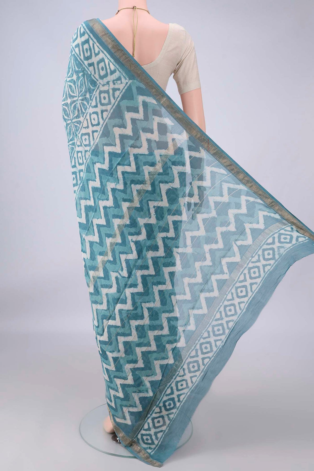 Flat view of Maya Blue Maheshwari Cotton Saree with Batik Print on the body and Zari Border. 