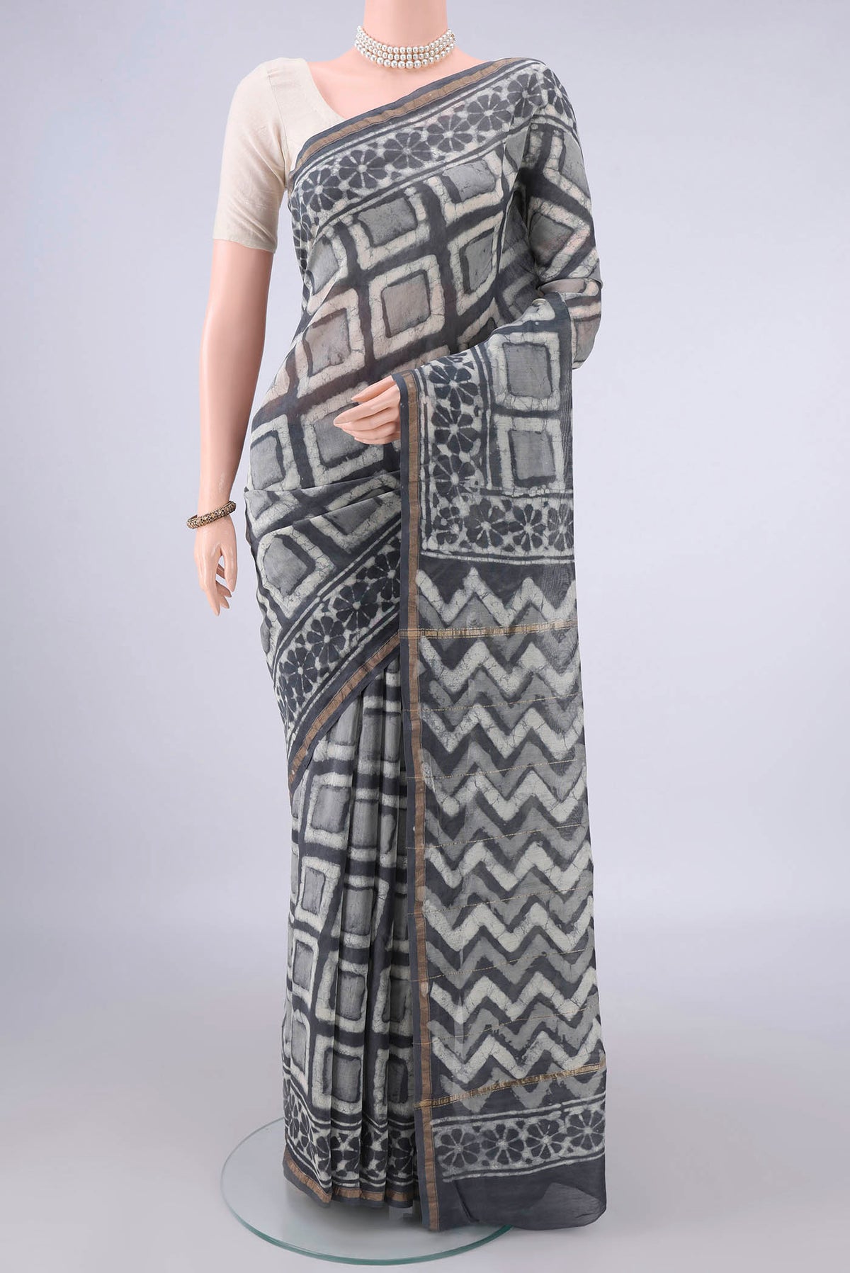 Grey Chanderi Cotton Saree with Batik Print on the body and Thin Zari Line.  displayed on a mannequin