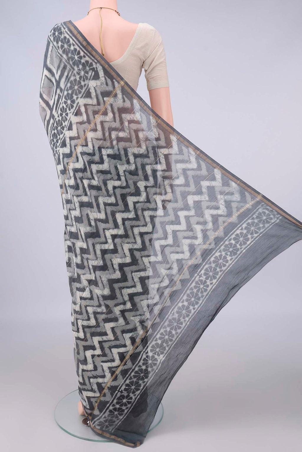 Flat view of Grey Chanderi Cotton Saree with Batik Print on the body and Thin Zari Line. 
