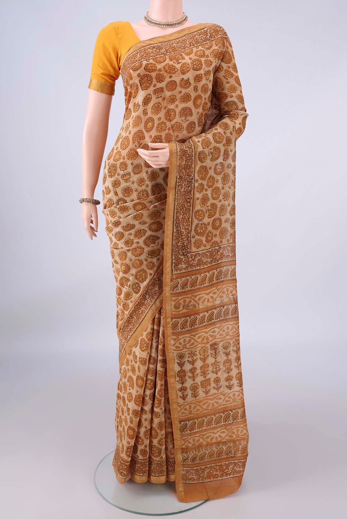 Sandal Chanderi Cotton Saree with Batik Print on the body and Thin Zari Line.  displayed on a mannequin