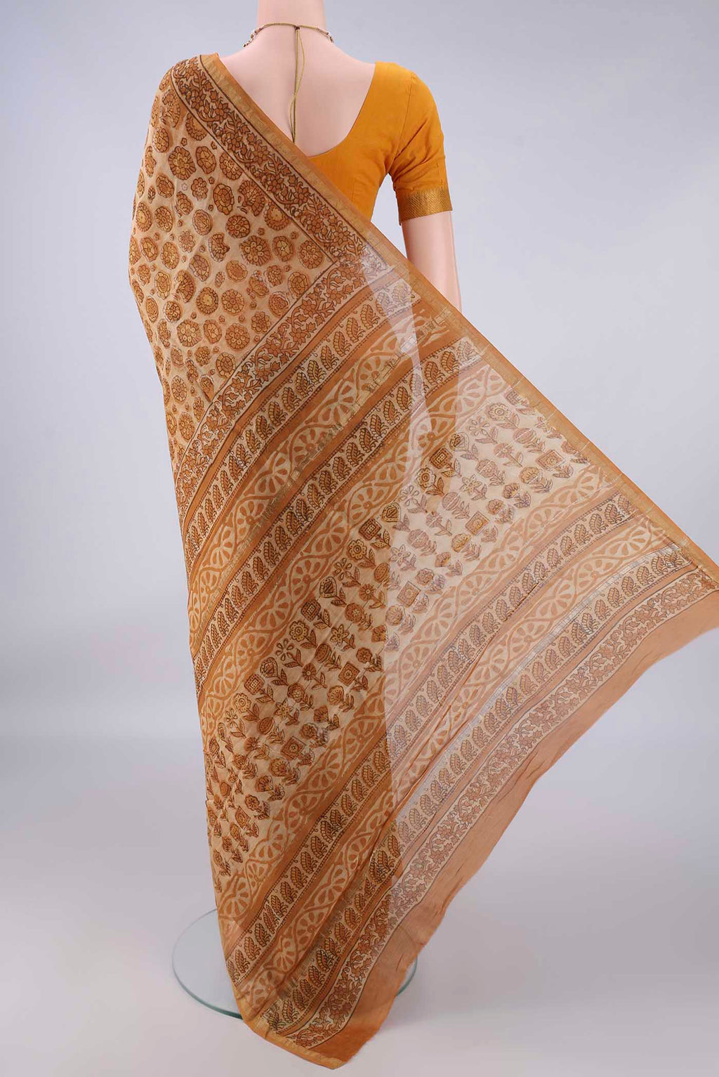 Flat view of Sandal Chanderi Cotton Saree with Batik Print on the body and Thin Zari Line. 