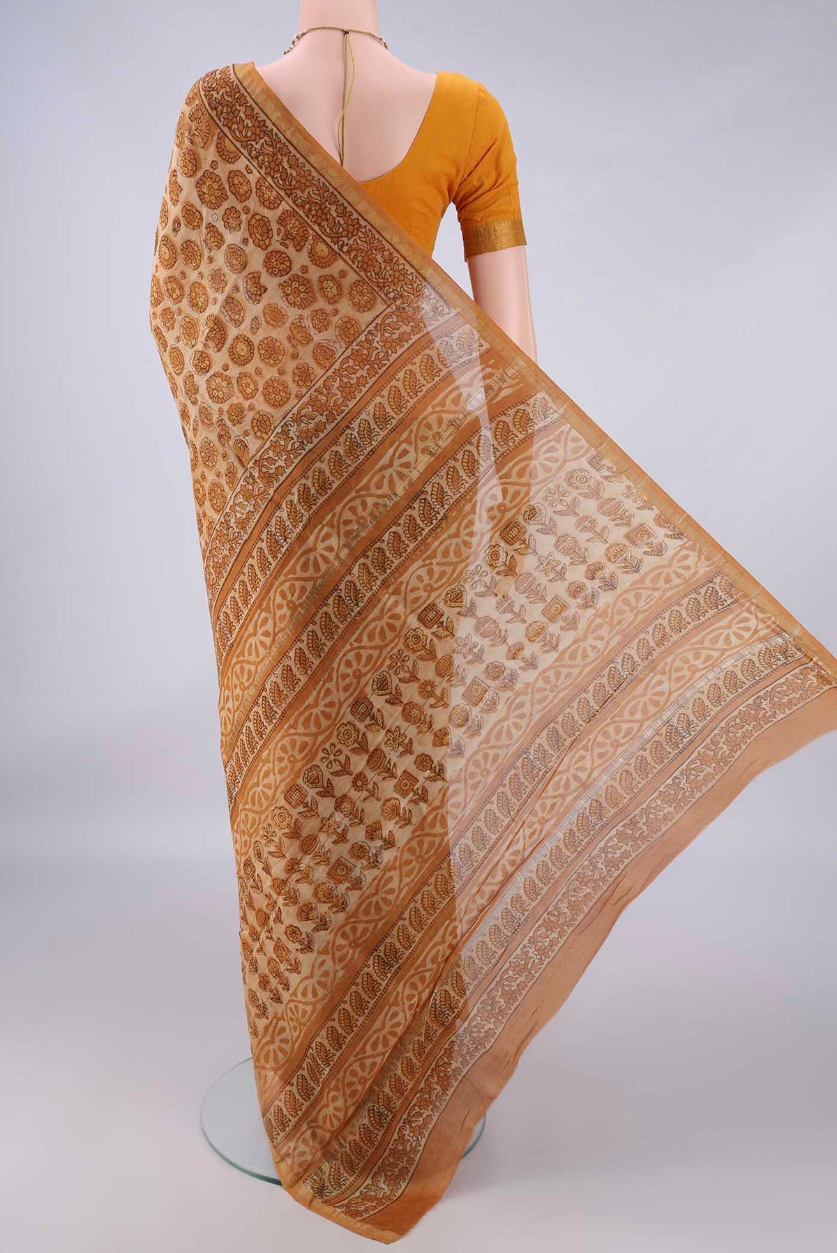 Flat view of Sandal Chanderi Cotton Saree with Batik Print on the body and Thin Zari Line. 
