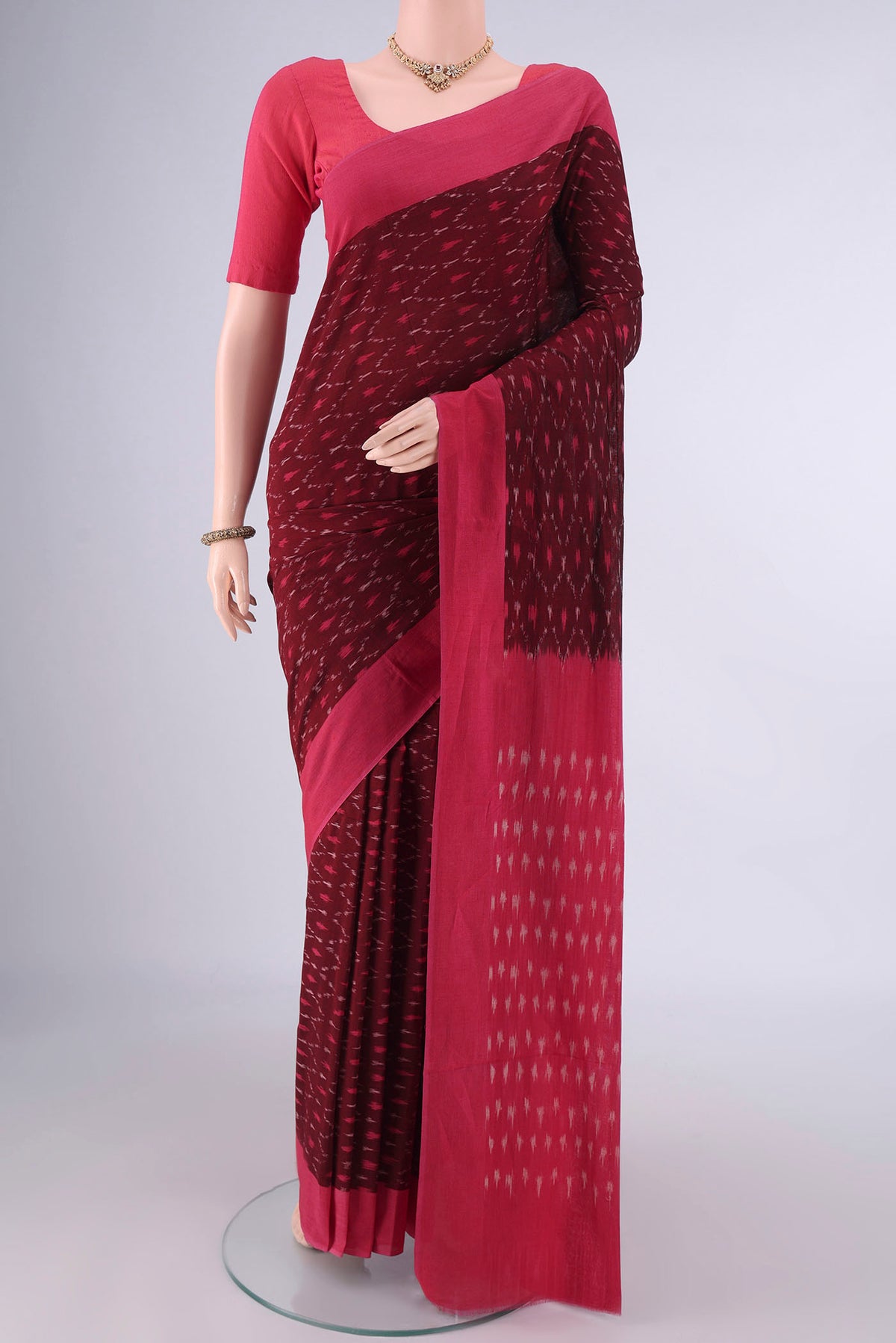 Maroon Pochampally Cotton Saree with Ikat design on the body and Plain Border.  displayed on a mannequin