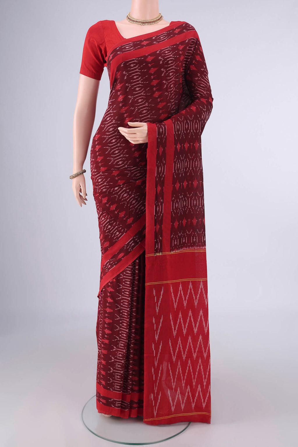 Maroon Pochampally Cotton Saree with Ikat design on the body and Ikat Border.  displayed on a mannequin