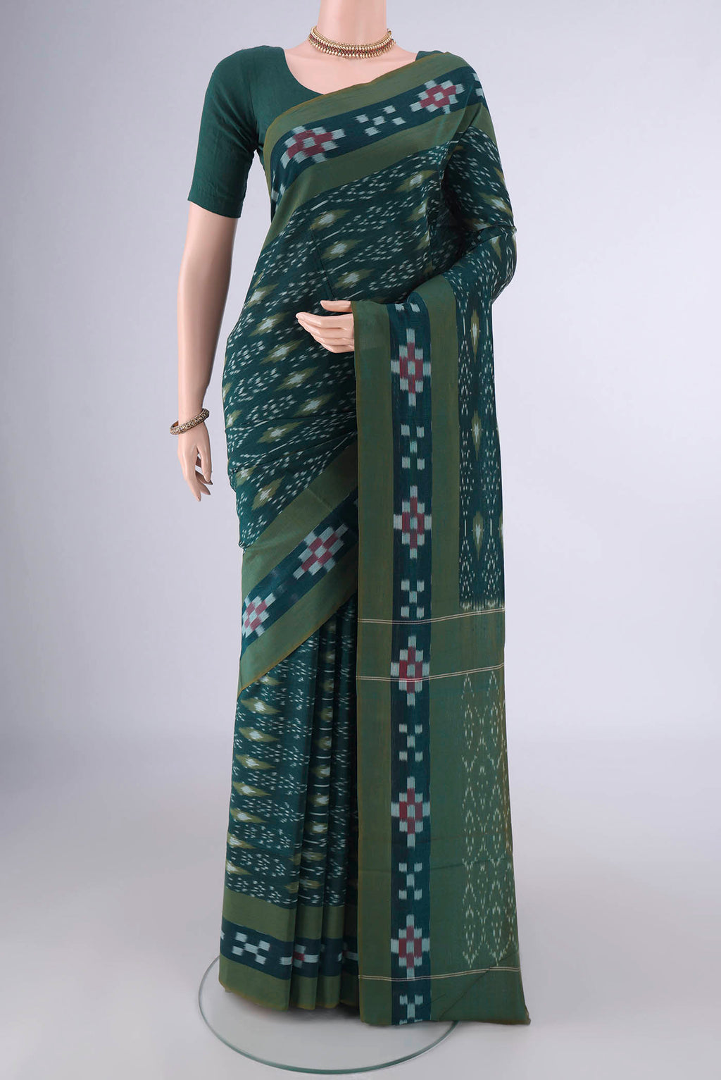 Bottle Green Pochampally Cotton Saree with Ikat design on the body and Ikat Border.  displayed on a mannequin