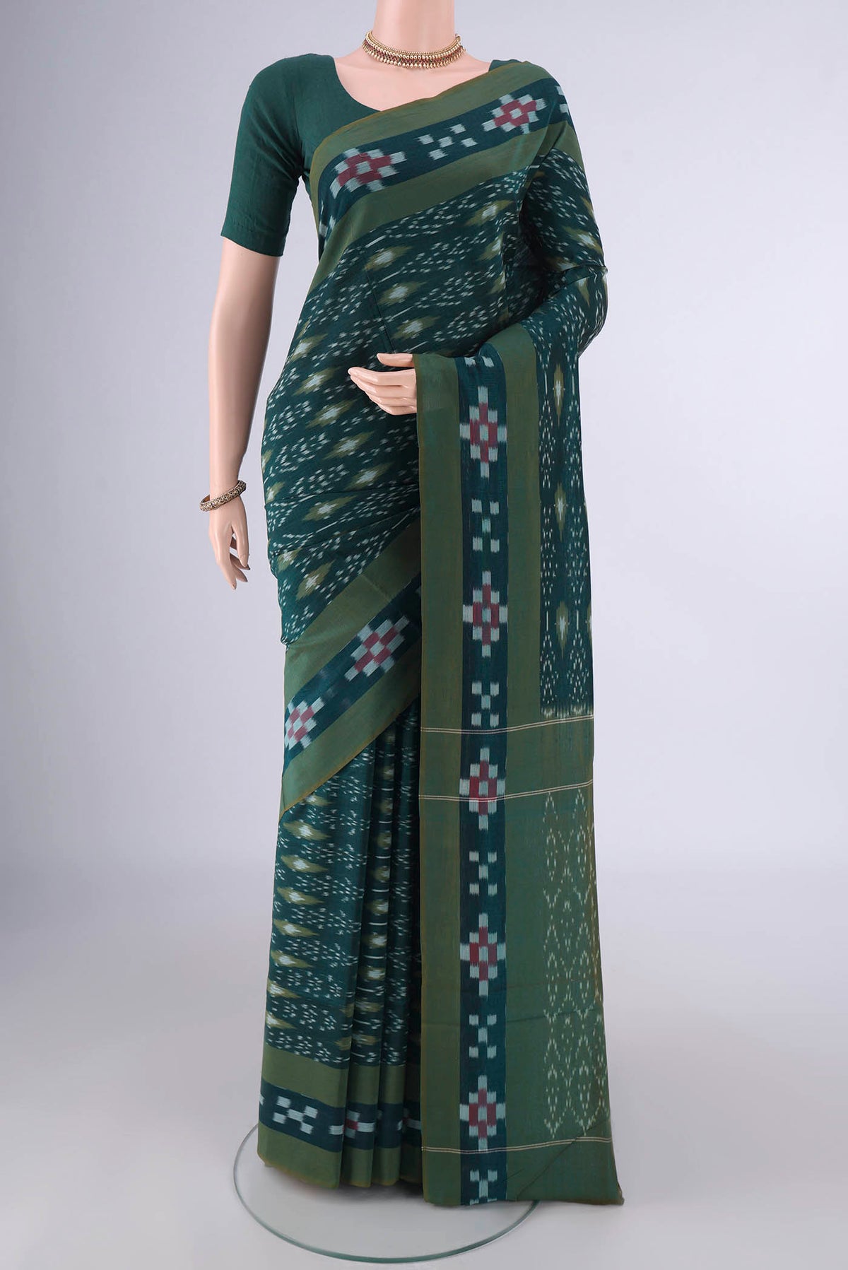 Bottle Green Pochampally Cotton Saree with Ikat design on the body and Ikat Border.  displayed on a mannequin