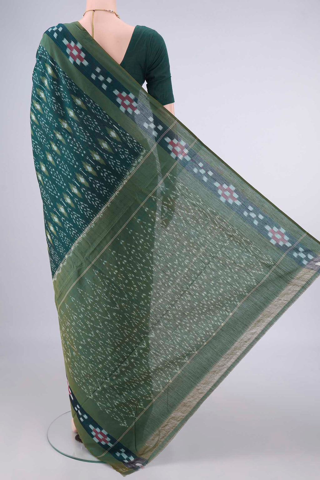 Flat view of Bottle Green Pochampally Cotton Saree with Ikat design on the body and Ikat Border. 