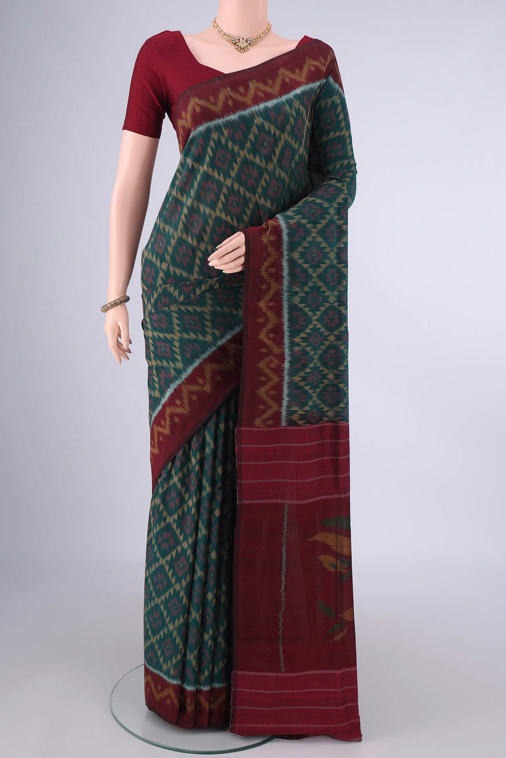 Bottle Green Pochampally Cotton Saree with Ikat design on the body and Ikat Border.  displayed on a mannequin