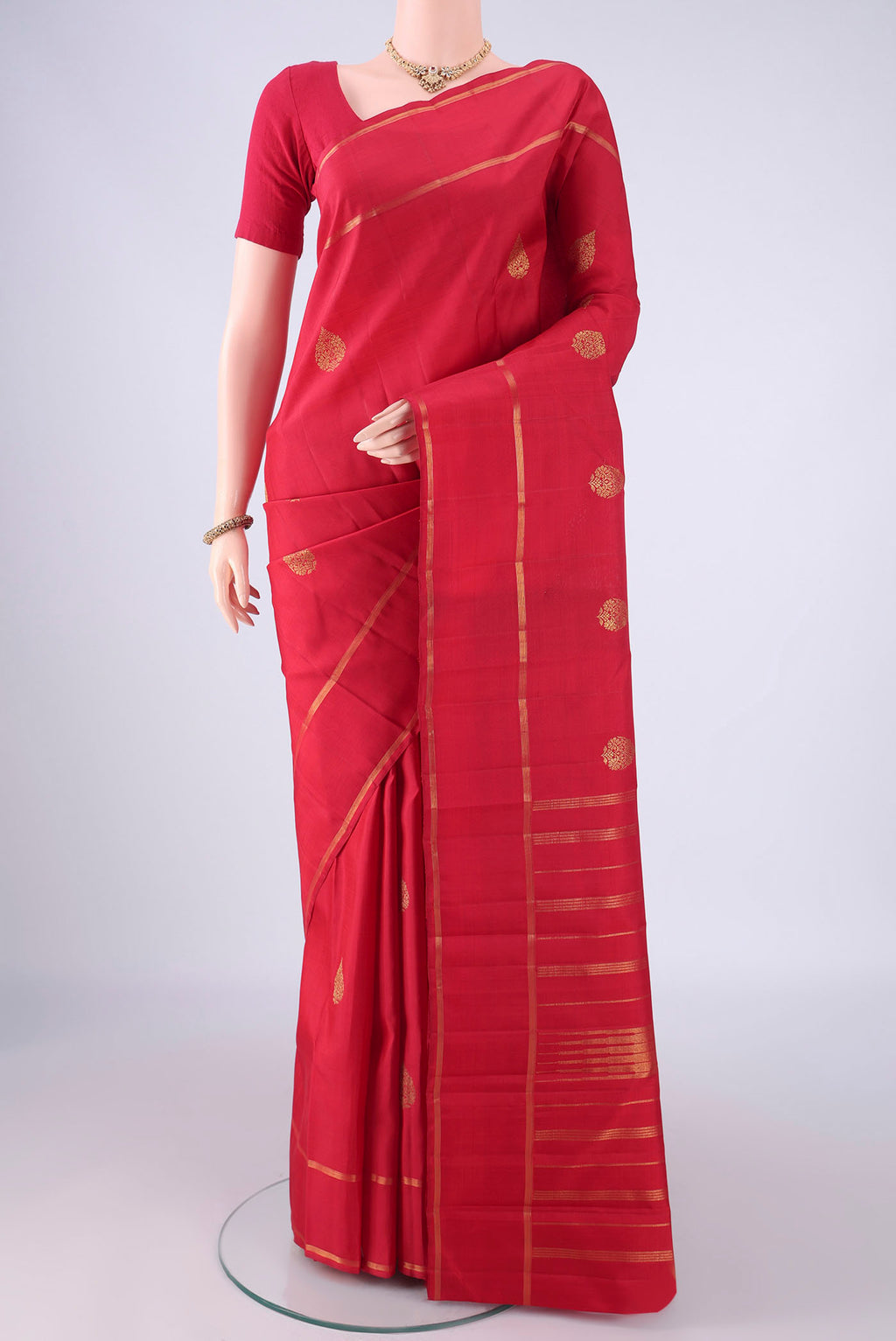 Pure Silk Red Kanjivaram Silk Saree with Zari Butta on the body and Zari Border.  displayed on a mannequin