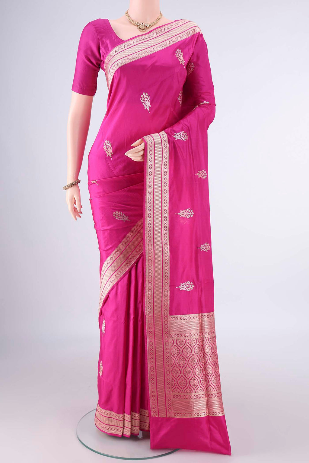 Pure Silk Rani Pink Banarasi Saree with Zari Butta on the body and Zari Border.  displayed on a mannequin