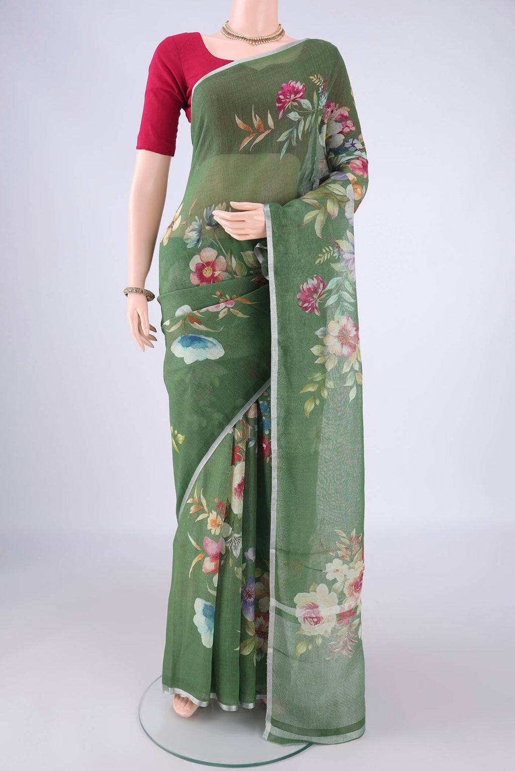 Green Linen Saree with Floral Print on the body and Zari Border.  displayed on a mannequin