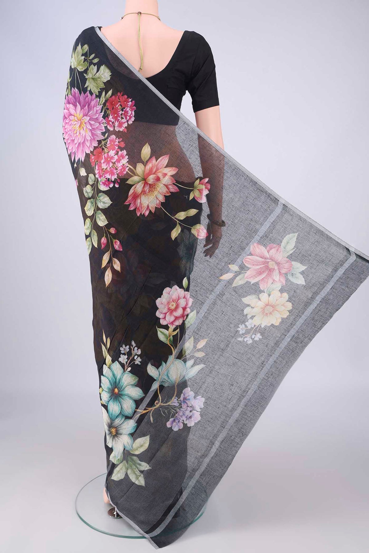 Flat view of Black Linen Saree with Floral Print on the body and Zari Border. 