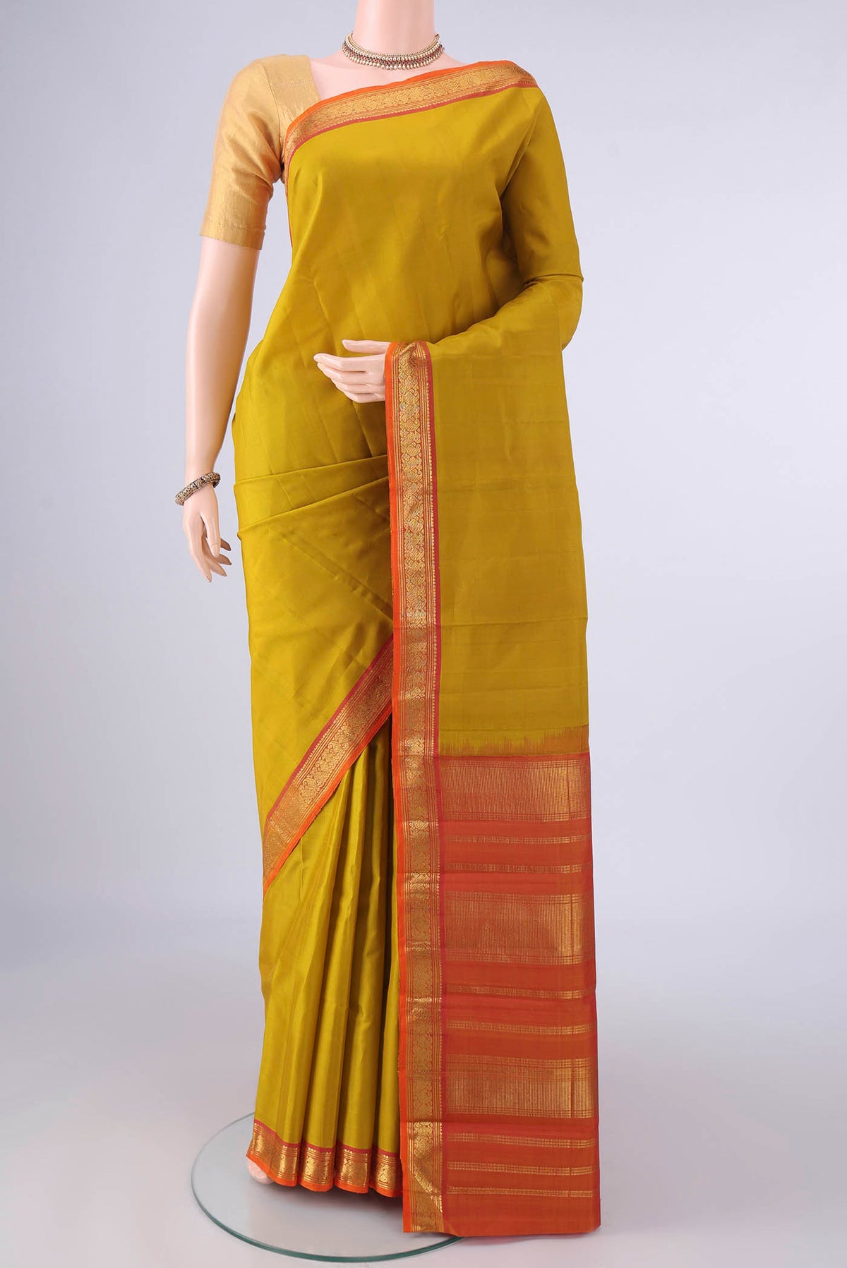 Pure Silk Mustard Kanjivaram Saree with Plain Body and Zari Border.  displayed on a mannequin