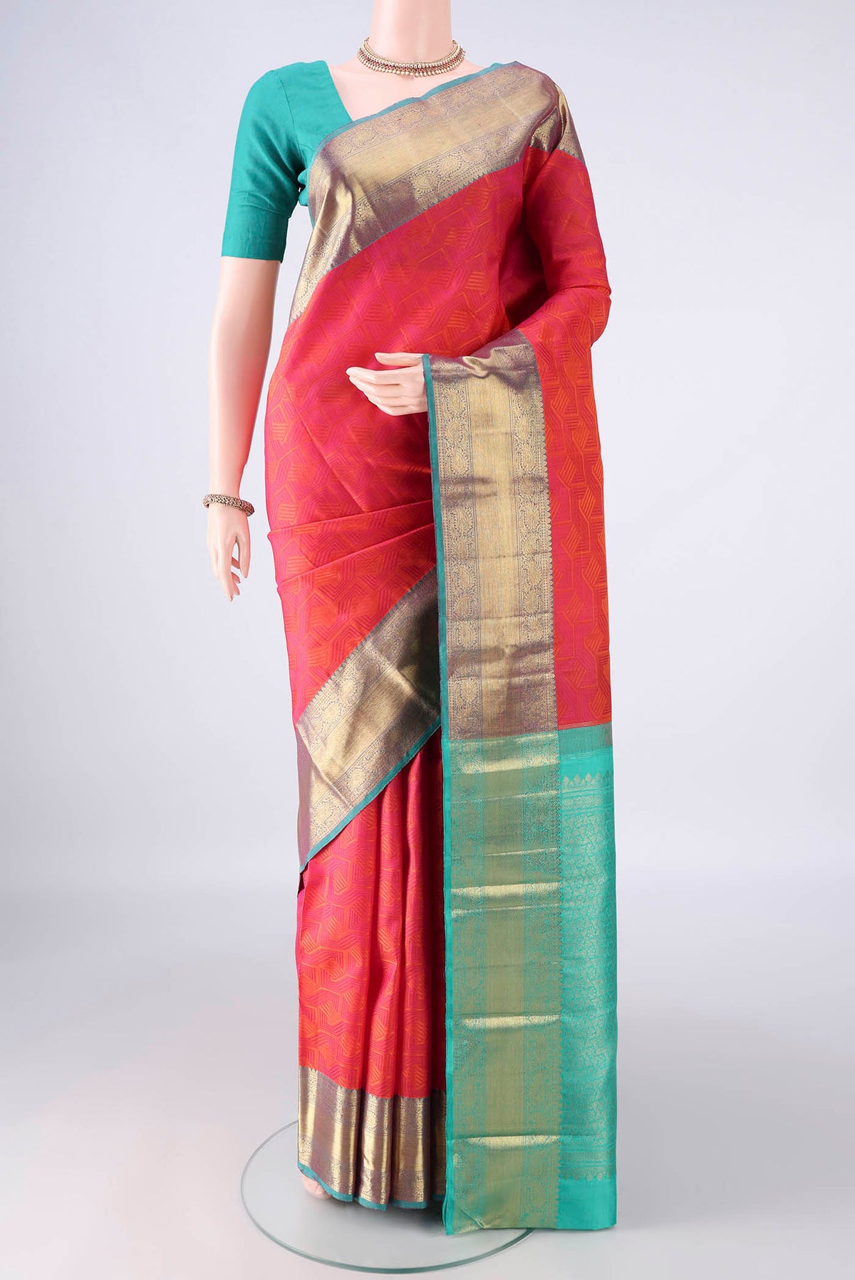 Pure Silk Brick Orange Kanchipuram Saree with Jacquard design on the body and Zari Border.  displayed on a mannequin