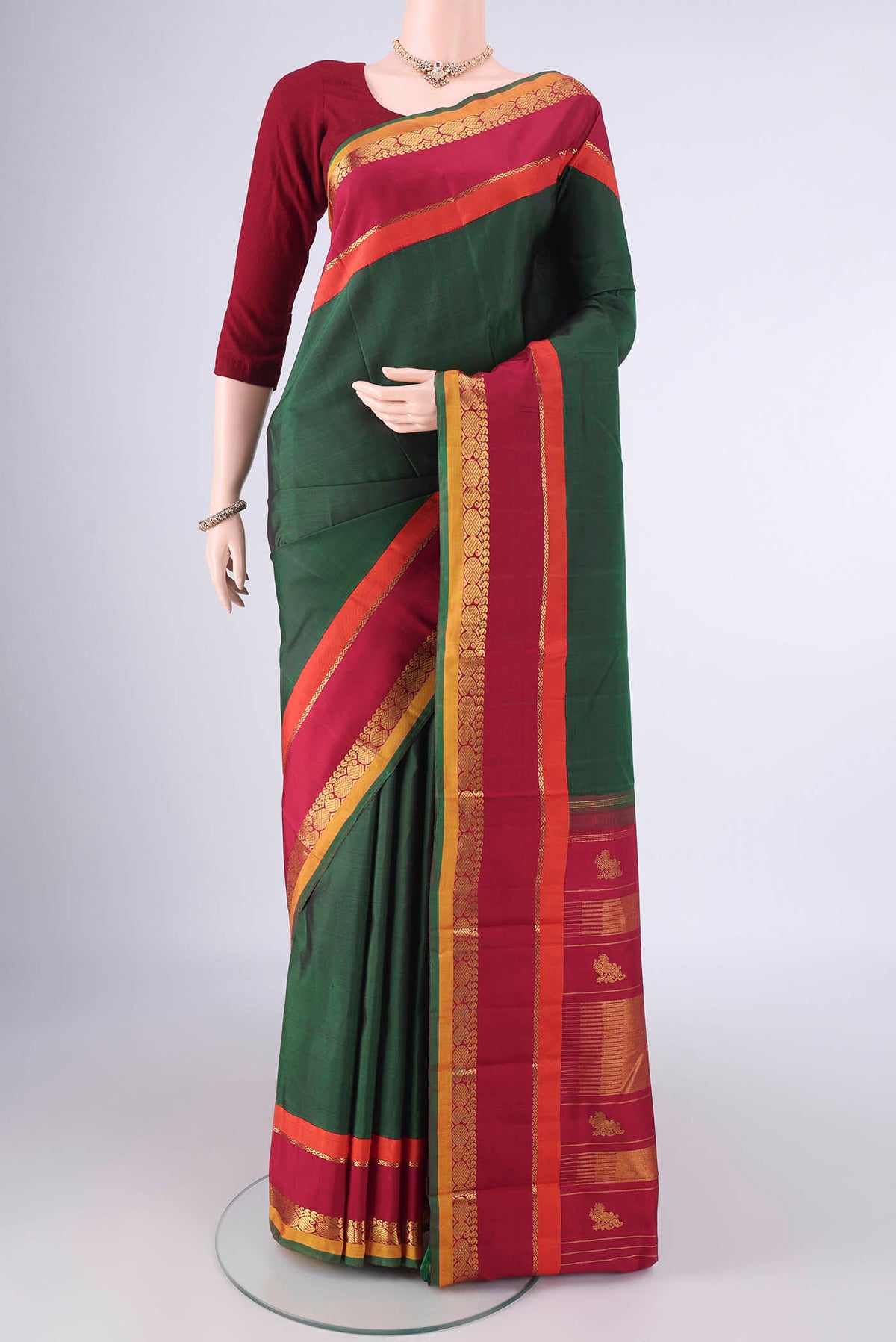 Pure Silk Bottle Green Kanjivaram Saree with Plain Body and Zari Border.  displayed on a mannequin