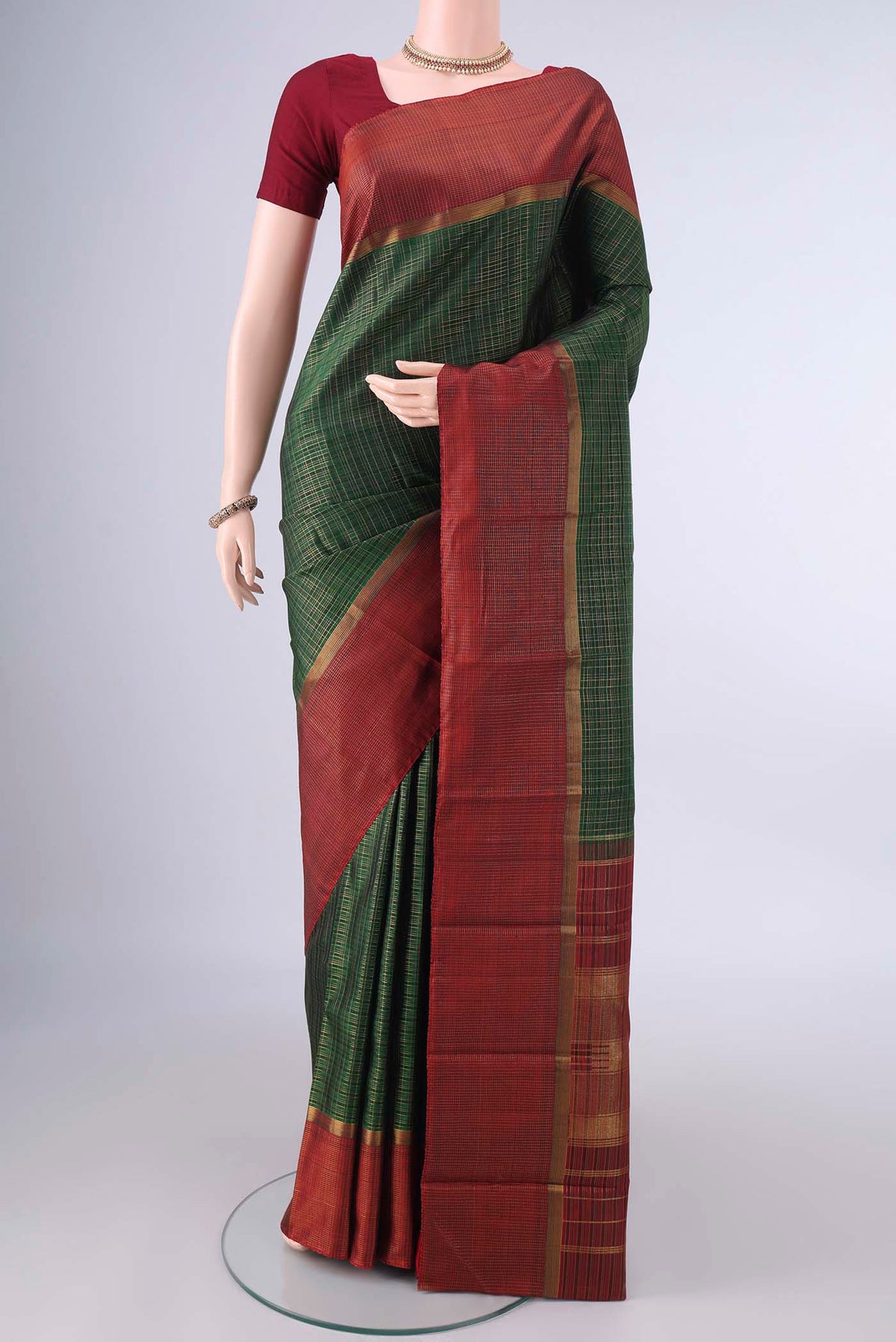 Pure Silk Bottle Green Kanjivaram Saree with Checked design on the body and Zari Border.  displayed on a mannequin