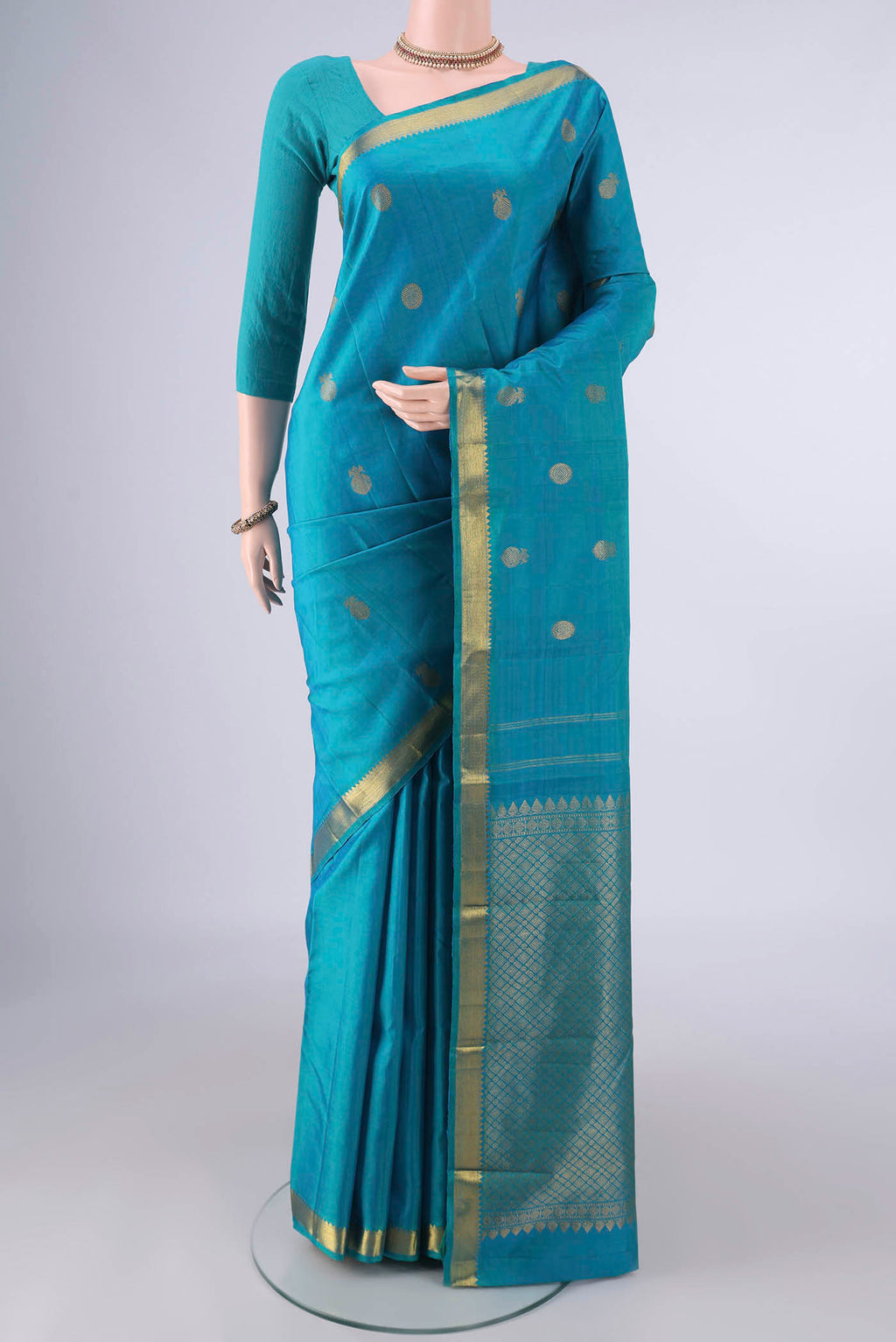 Pure Silk Turquoise Kanchipuram Saree with Zari Butta on the body and Zari Border.  displayed on a mannequin