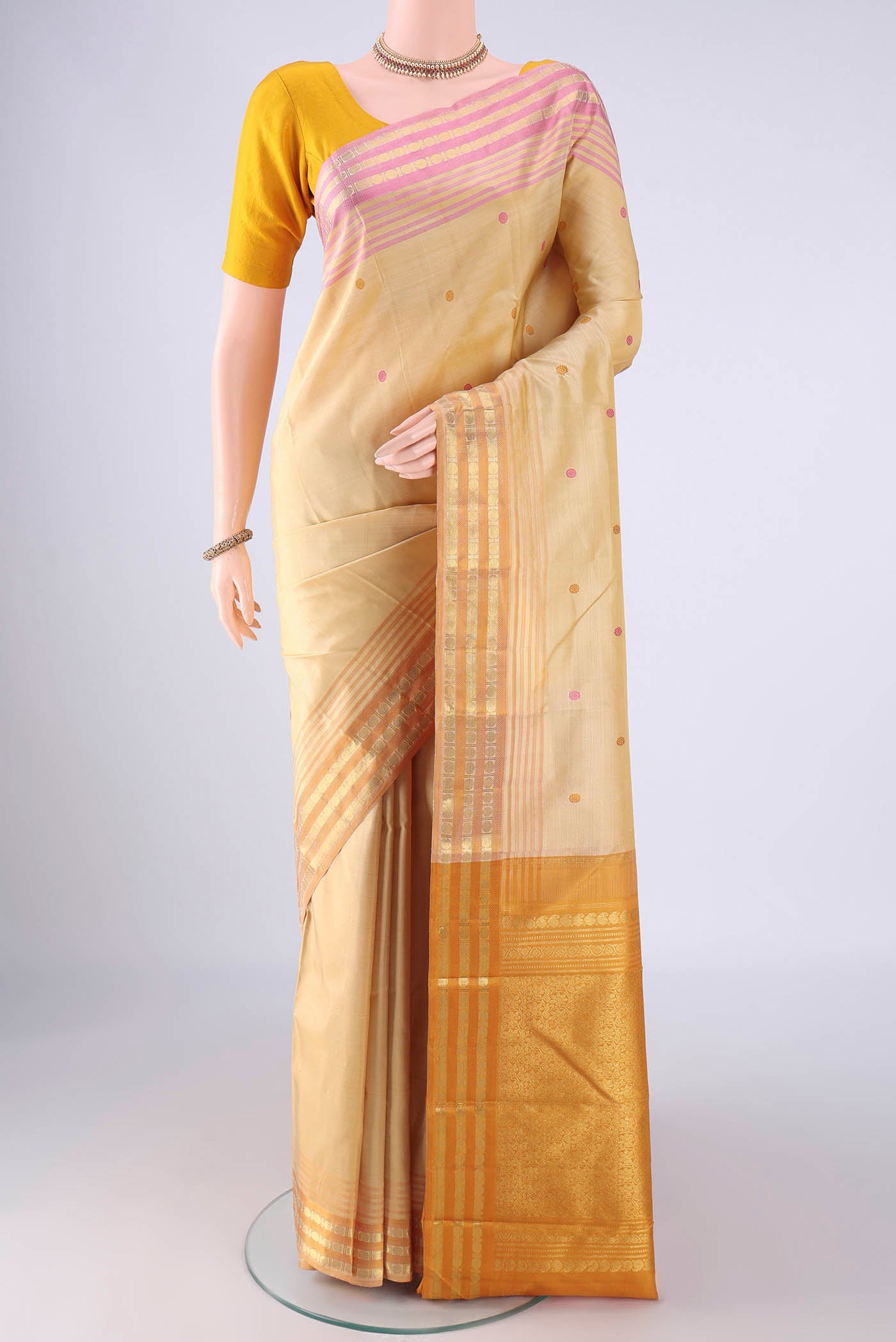 Sandal Kanjivaram Silk Saree with Thread Butta on the body and Ganga Jamuna Border.  displayed on a mannequin