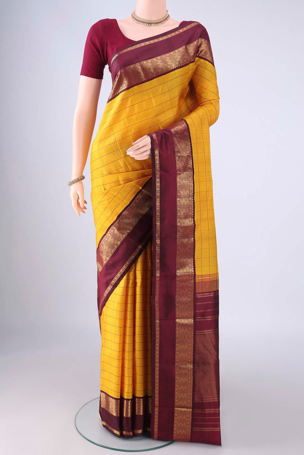 Yellow Kanjivaram Silk Saree with Checked design on the body and Zari Border.  displayed on a mannequin