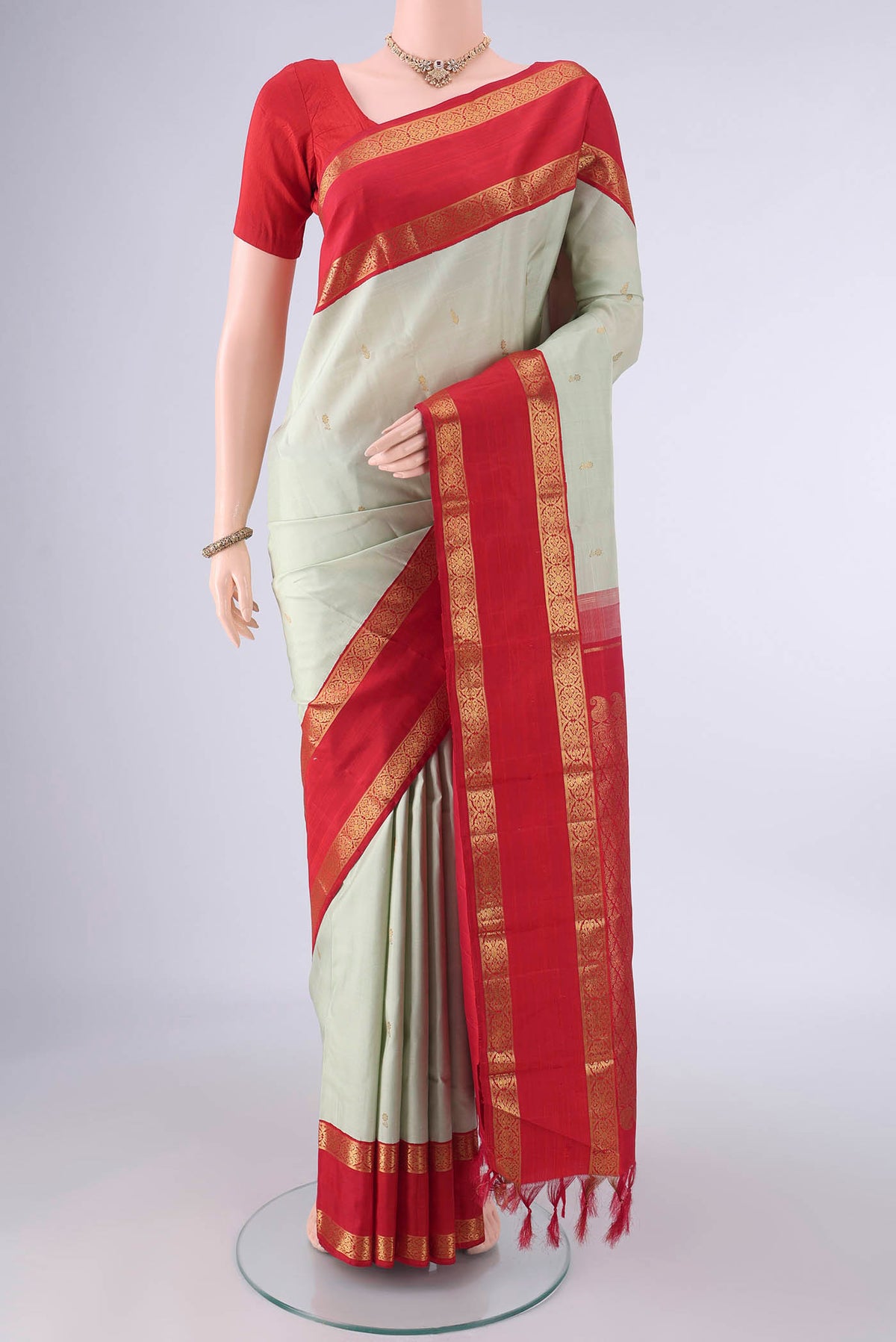 Pure Silk Light Green Kanjivaram Saree with Zari Butta on the body and Zari Border.  displayed on a mannequin